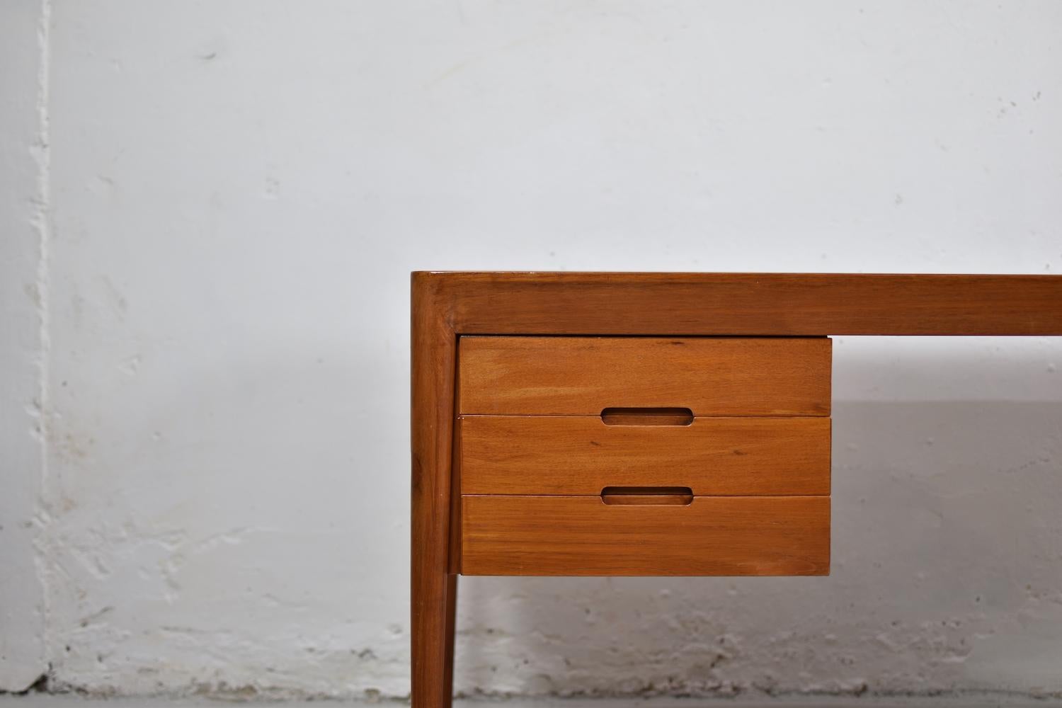 Suberb high quality free standing desk by Erik Riisager for Haslev Møbelfabrik, Denmark, 1960s. This elegant desk is made out of teak and features three drawers on the left, the top drawer has teak tray inside which can be pulled over the drawer and