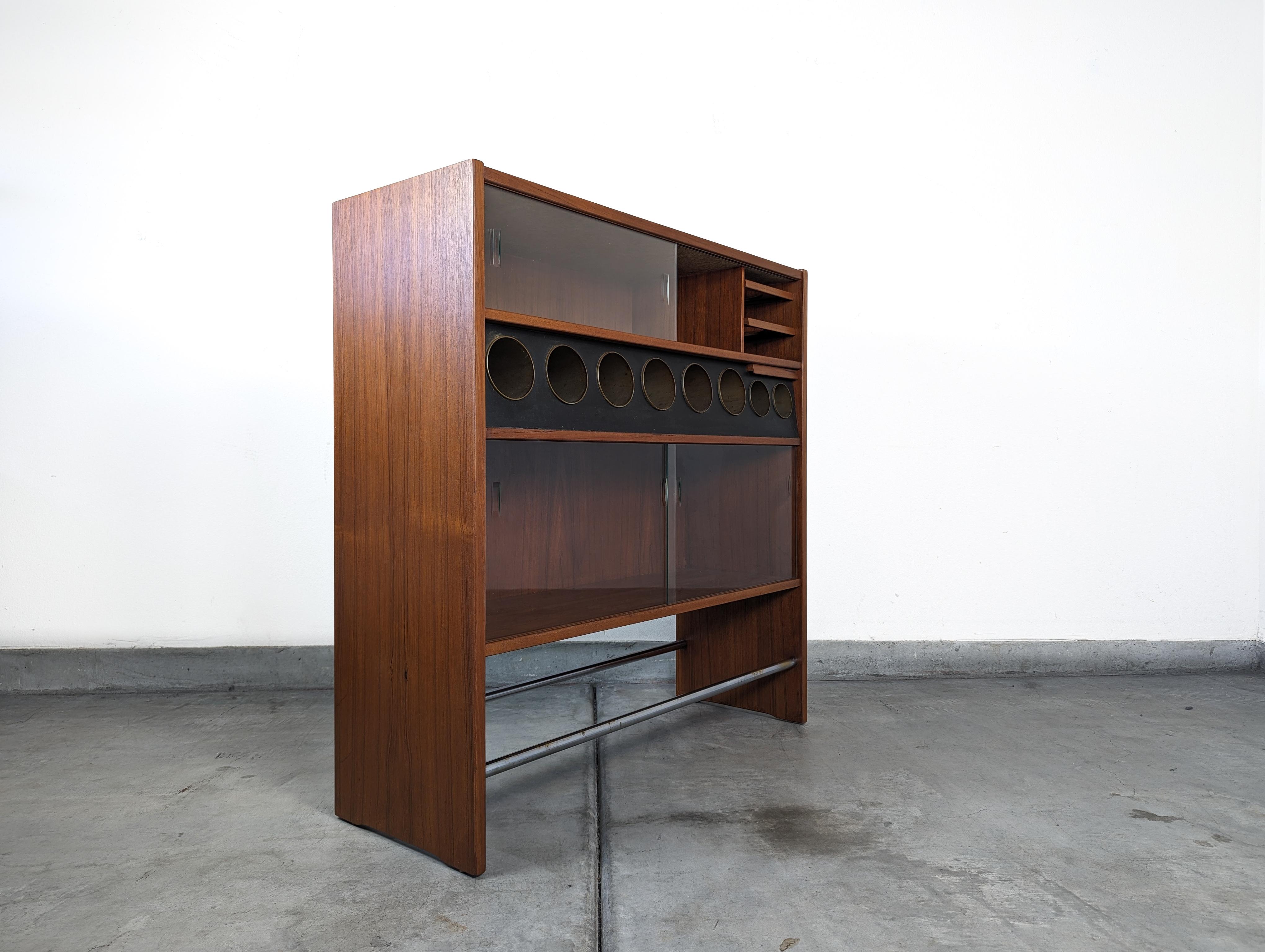 Presenting an exquisite piece of history and craftsmanship, this Danish Mid-Century Modern Walnut HM3 Dry Bar is a treasure for any connoisseur of fine design. Designed by the renowned Poul Heltborg for Heltborg Møbler in the 1960s, it stands as a