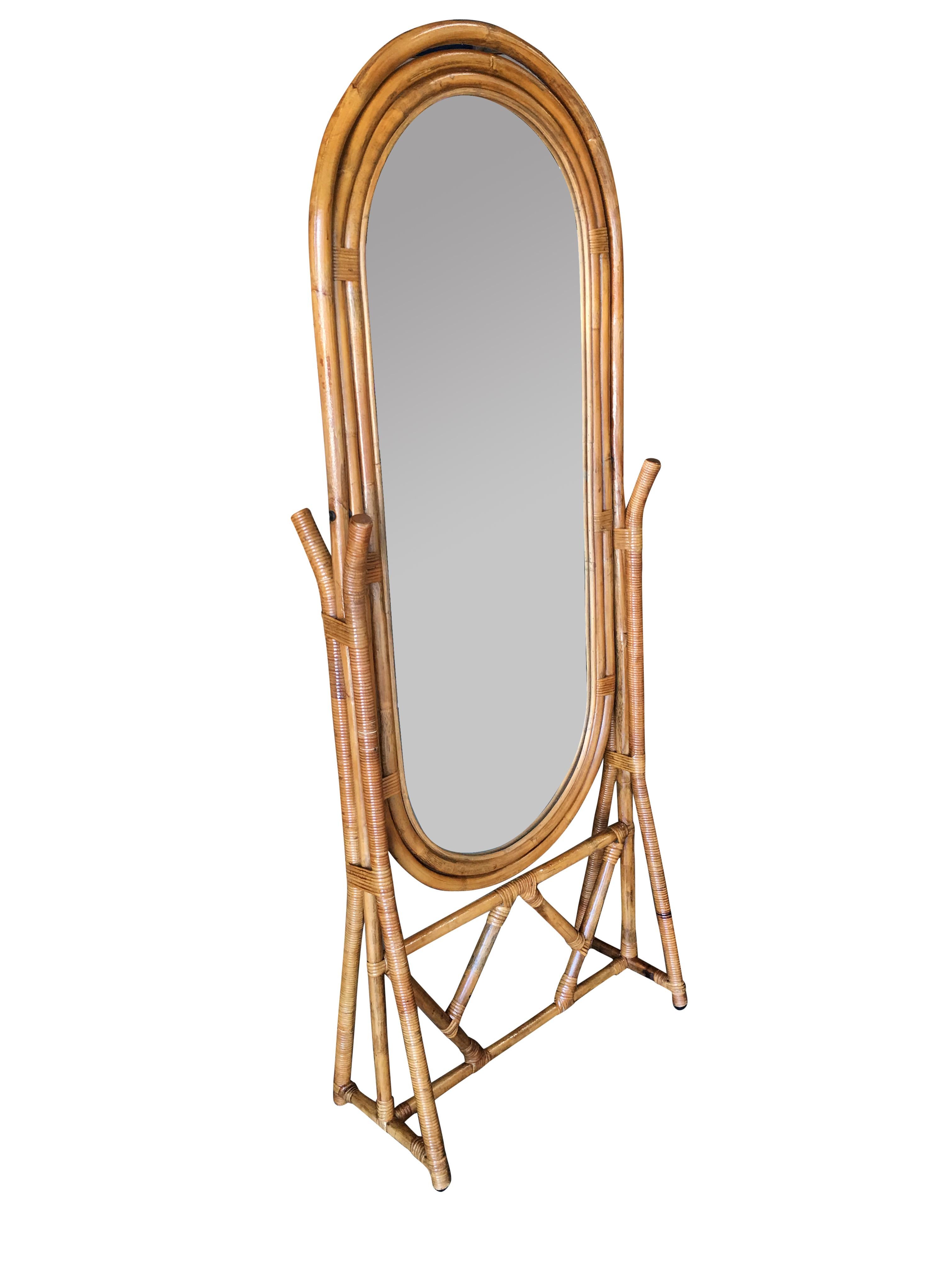Freestanding full length rattan floor mirror by Interlude Home Inc with decorative wood back, bronze fixtures and fancy wicker wrappings, 

circa 1980.

Designed in the manner of Paul Frankl.

Restored to new for you.

All rattan, bamboo and wicker