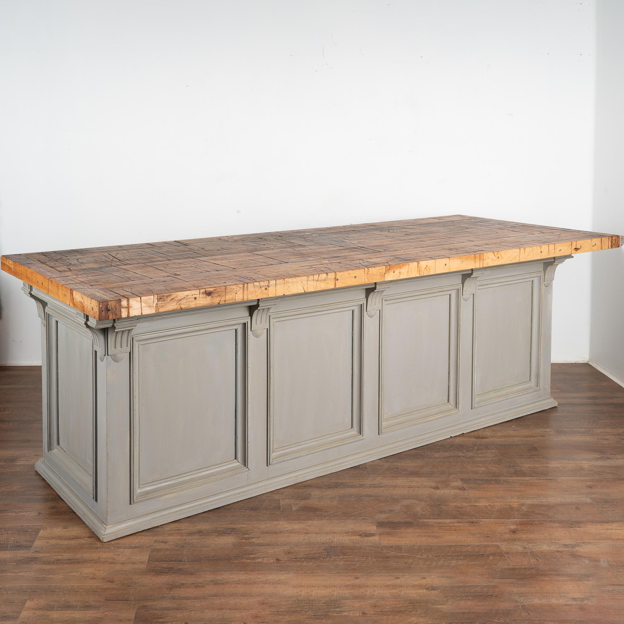 This old shop counter from France has been given new life with a custom professional gray painted finish creating a fresh look for a modern kitchen island.
The top is made from old boxcar flooring (from a train); thick and heavy, it is filled with