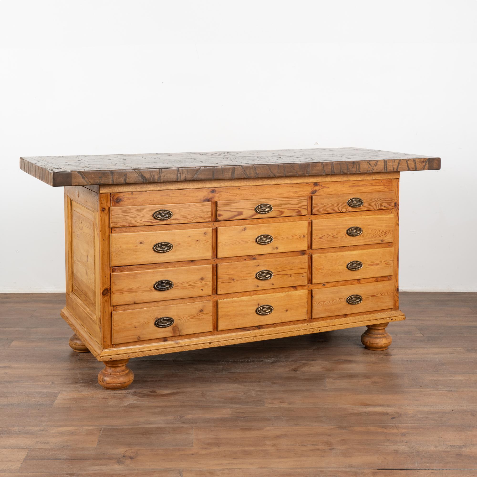 This impressive freestanding island will be the gathering place in any kitchen. This versatile piece originally served as a grocer's shop counter in the 1800's and is finished on all four sides. 
The front area served as storage with 12 drawers with