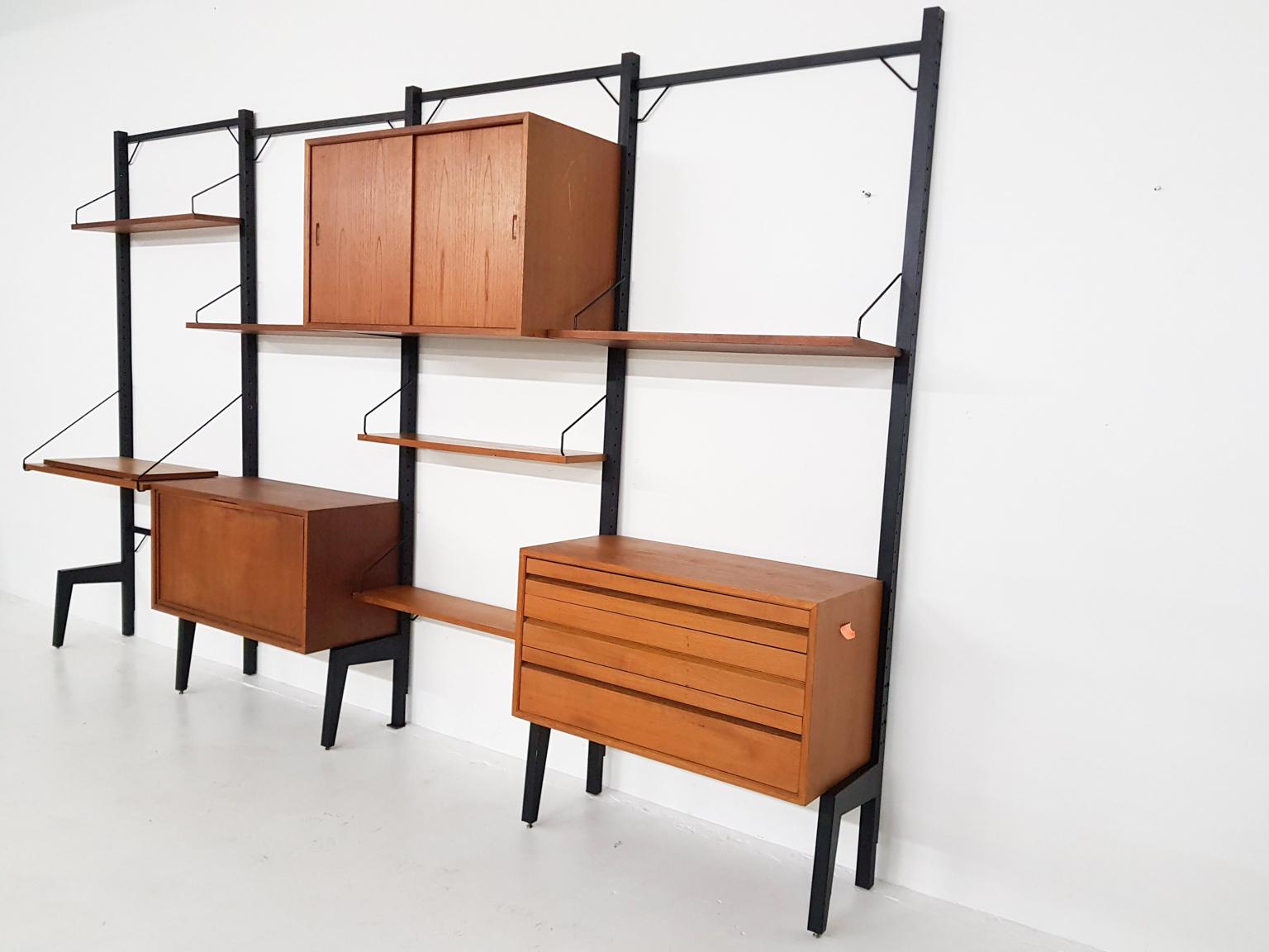 Large free standing wall unit by Poul Cadovius for Royal System in teak. With 5 black metal risers.
Measures: 1 x TV shelf 40 x 80 cm (D x W)
1 x cabinet with sliding doors 52 x 40 x 80 cm (H x D x W)
1 x cabinet with valve 42.5 x 37.5 x 80 cm (H x