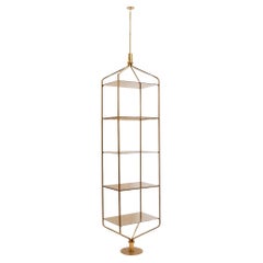 Free-standing shelf in gold-plated brass with smoked glass shelves. 1970s.