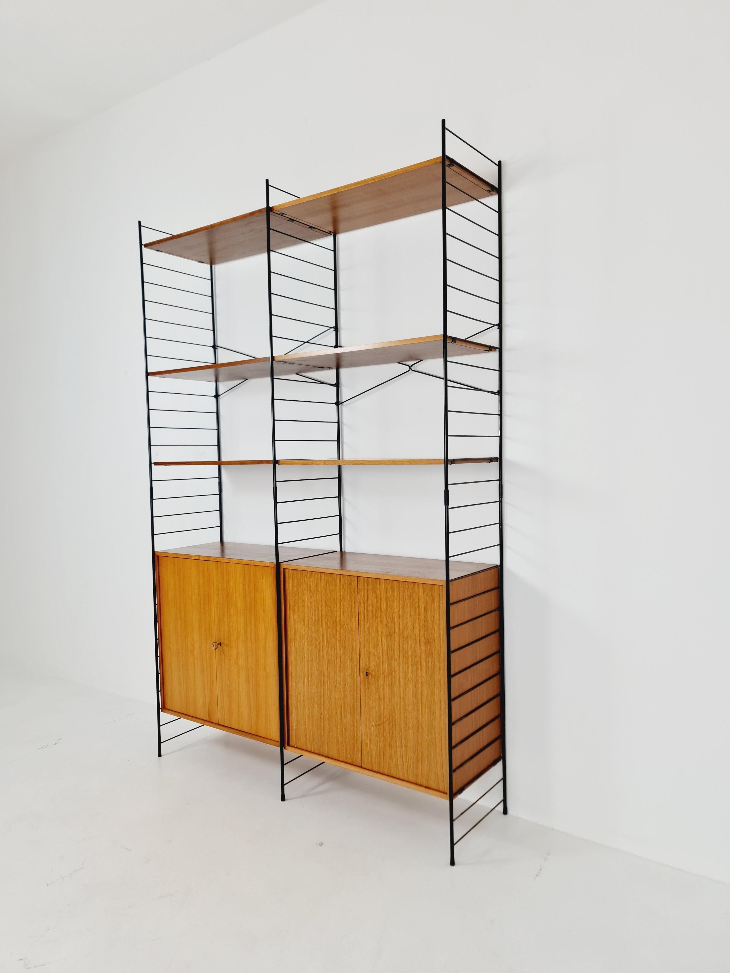 String shelf-system teak by WHB Germany, 1950s

Measurements:
Height : 225 cm
Width : 145 cm 
Depth : 40 cm 

Please inquiry for prices to your country before buying. 

A wooden crate may be used for intercontinental shipments for maximum