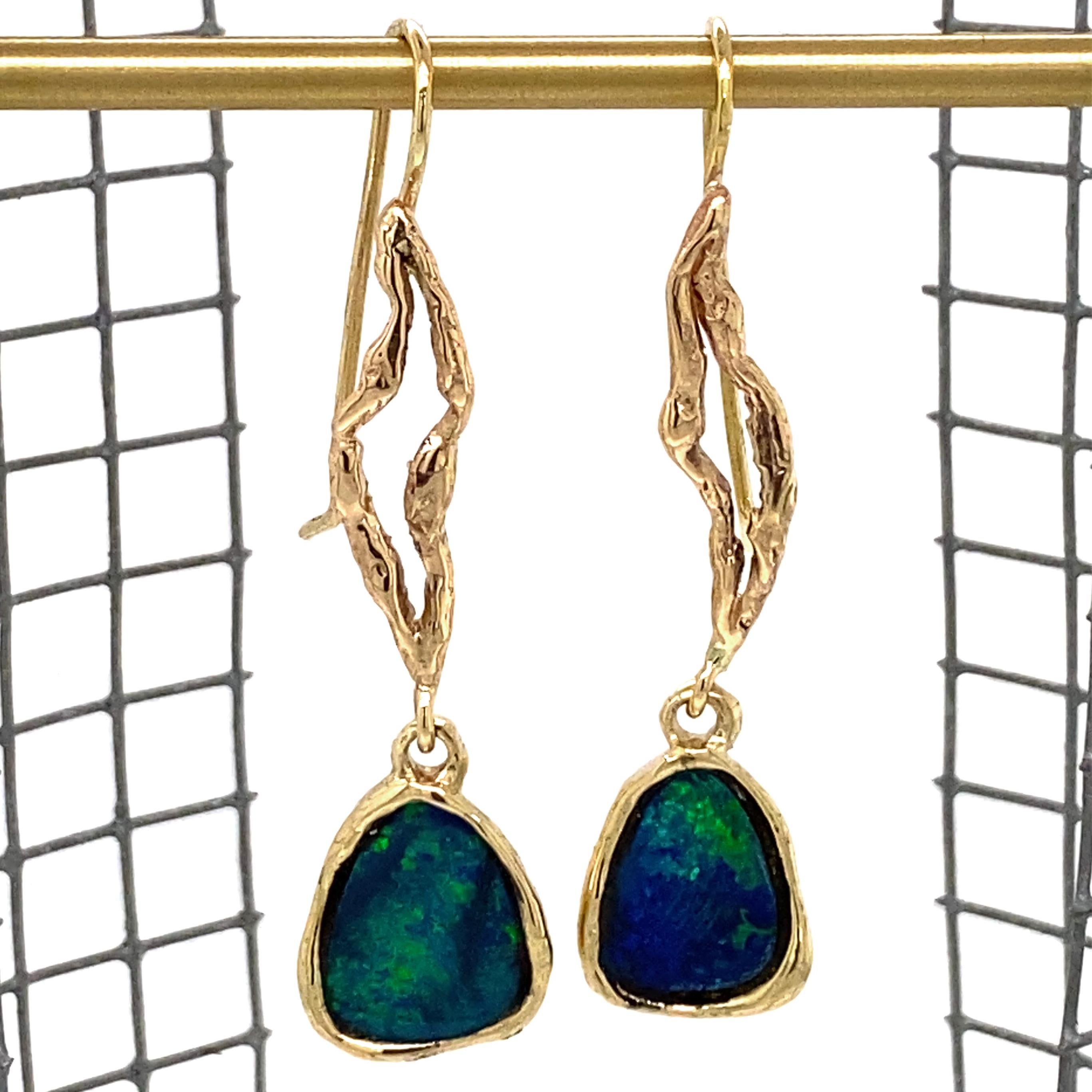 Two fiery blue and green Australian boulder opals seem to drip from strands of gold to create a pair of beautiful earrings by Eytan Brandes.

Each opal is roughly triangular in shape, approximately 11mm long and 8mm wide.  The stones are encased in