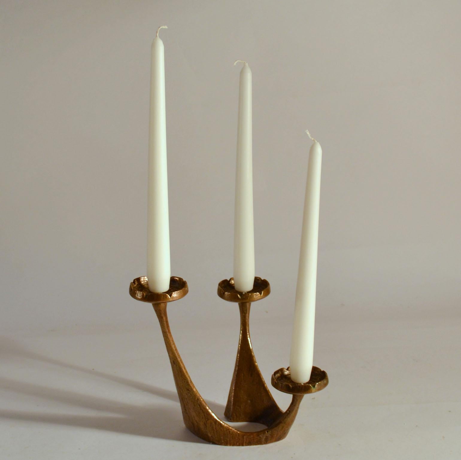Mid-Century Modern freeform bronze cast three-arm candleholder with soft curves and lines. Three arms on descending heights hold regular size to maximal 4 cm diameter candles.