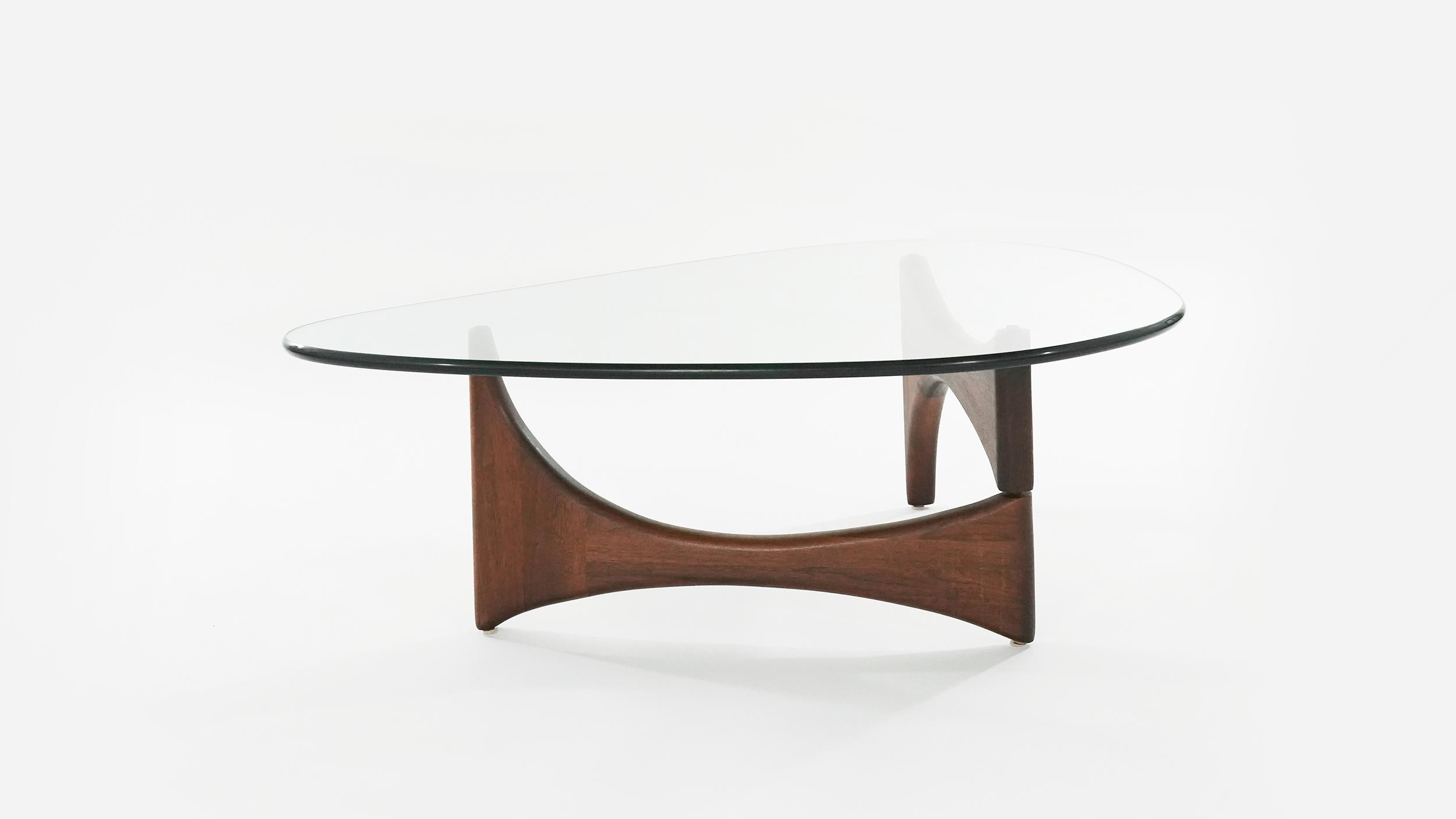 A freeform coffee table designed by Adrian Pearsall, circa 1950s.
Sculptural walnut bases fully restored. New glass top mimics dimensions and shape of the original.