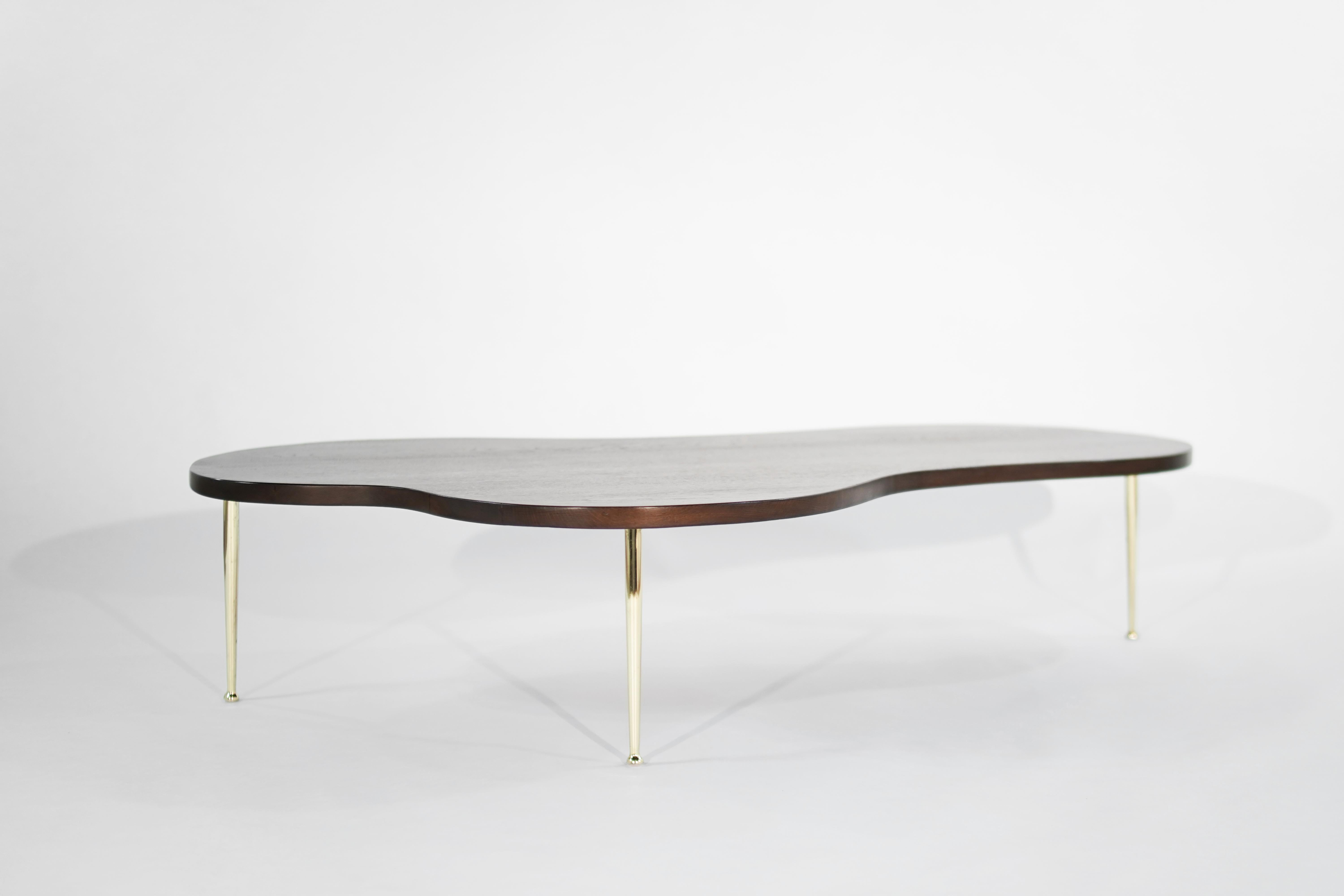 Iconic sculpted freeform coffee table designed by T.H. Robsjohn-Gibbings for Widdicomb. Fully restored oak top with hand polished tapered brass legs. Rare larger version.
  