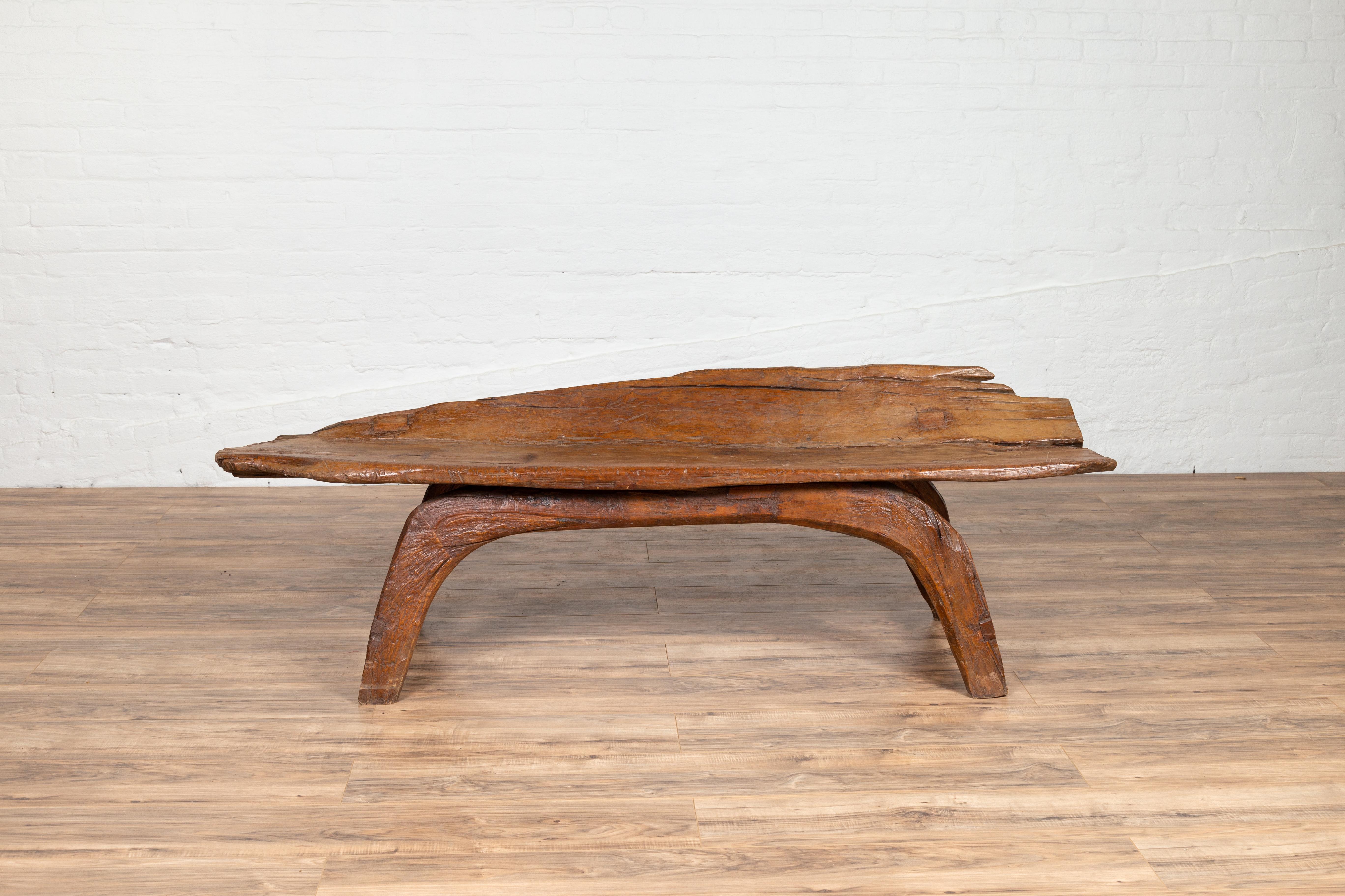 An antique freeform design Indonesian wooden bench found in the riverbed of Bali. This charming wooden bench delights our eye with its freeform rustic design. Found in the riverbed of Bali, it presents a wooden seat capable of accommodating three