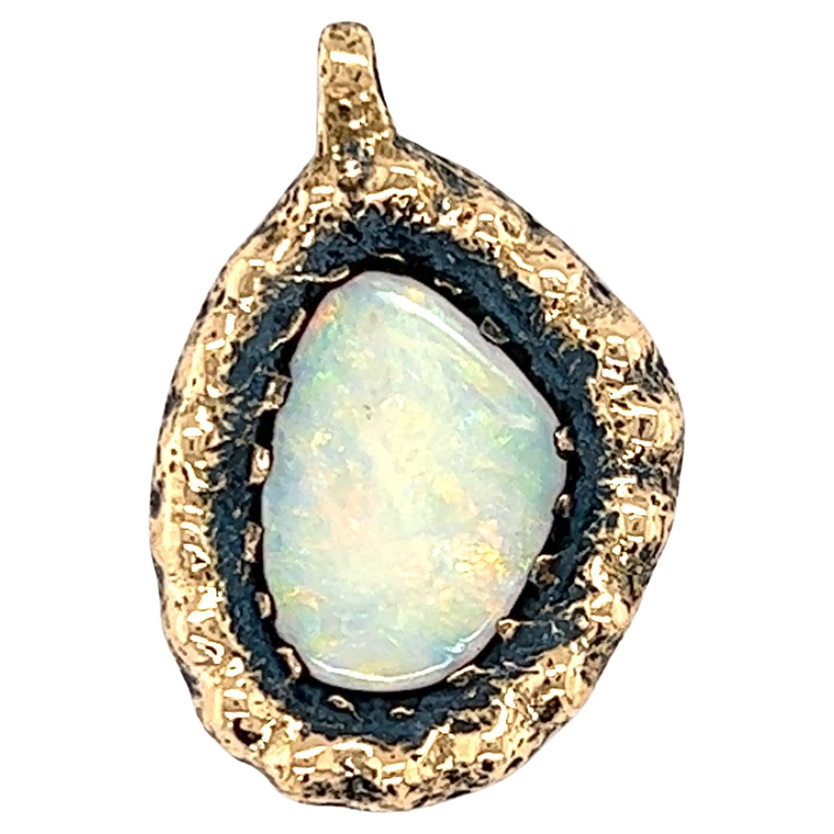 Un pendentif en or jaune 14 carats serti d'une opale naturelle de forme libre.  Le pendentif mesure 1 pouce de long et 0,50 pouce de large.  Circa 1970.