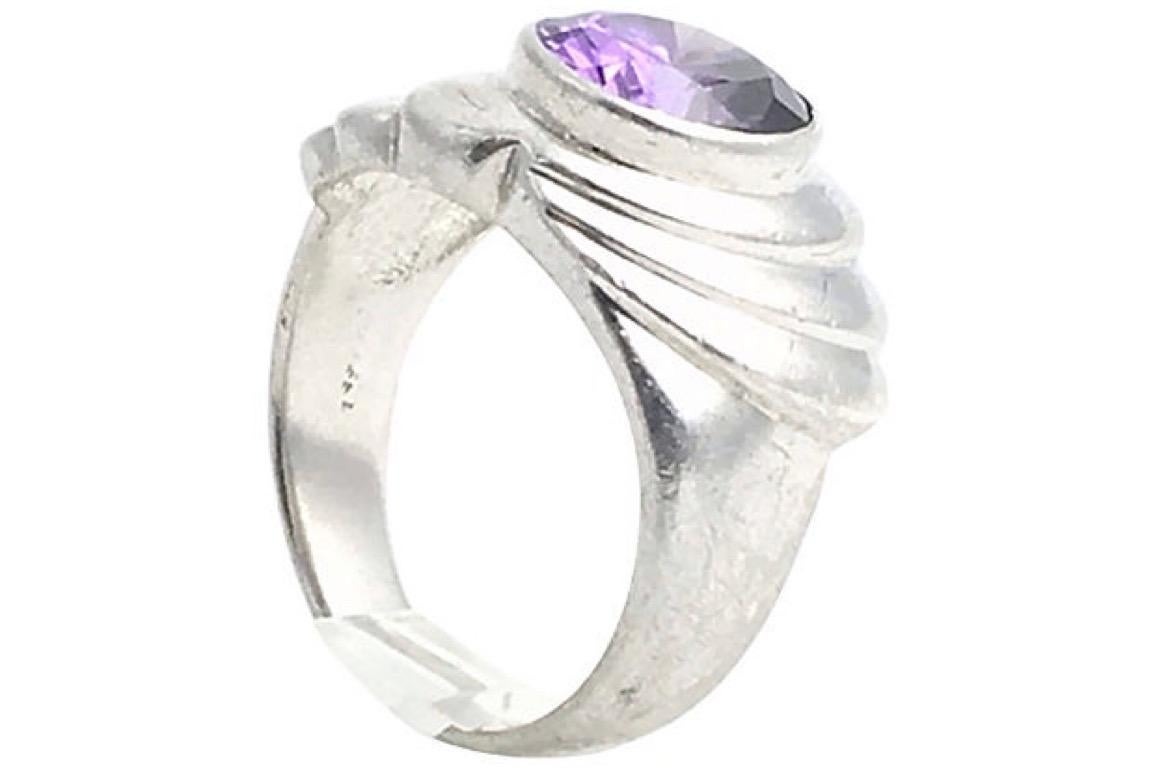 Freeform sterling silver ring set with an oval purple cubic zirconia in the center of the fan-motif mount. Size: 7; can be sized.