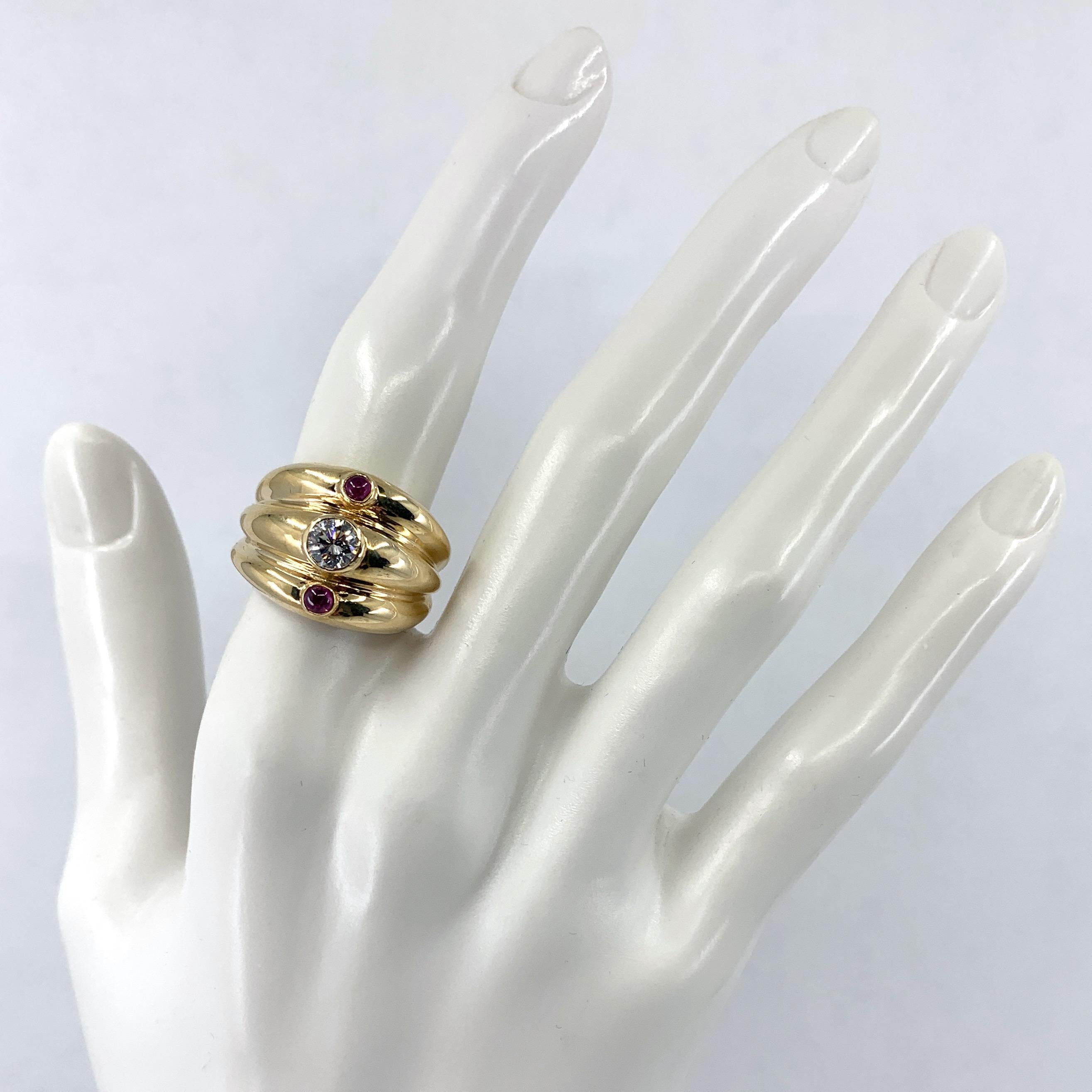 This modern turban ring in polished 14 karat yellow gold by Eytan Brandes is chubby and cheerful, with a clean, bright white half-carat diamond plus two rosy ruby cabochons.  

The three 