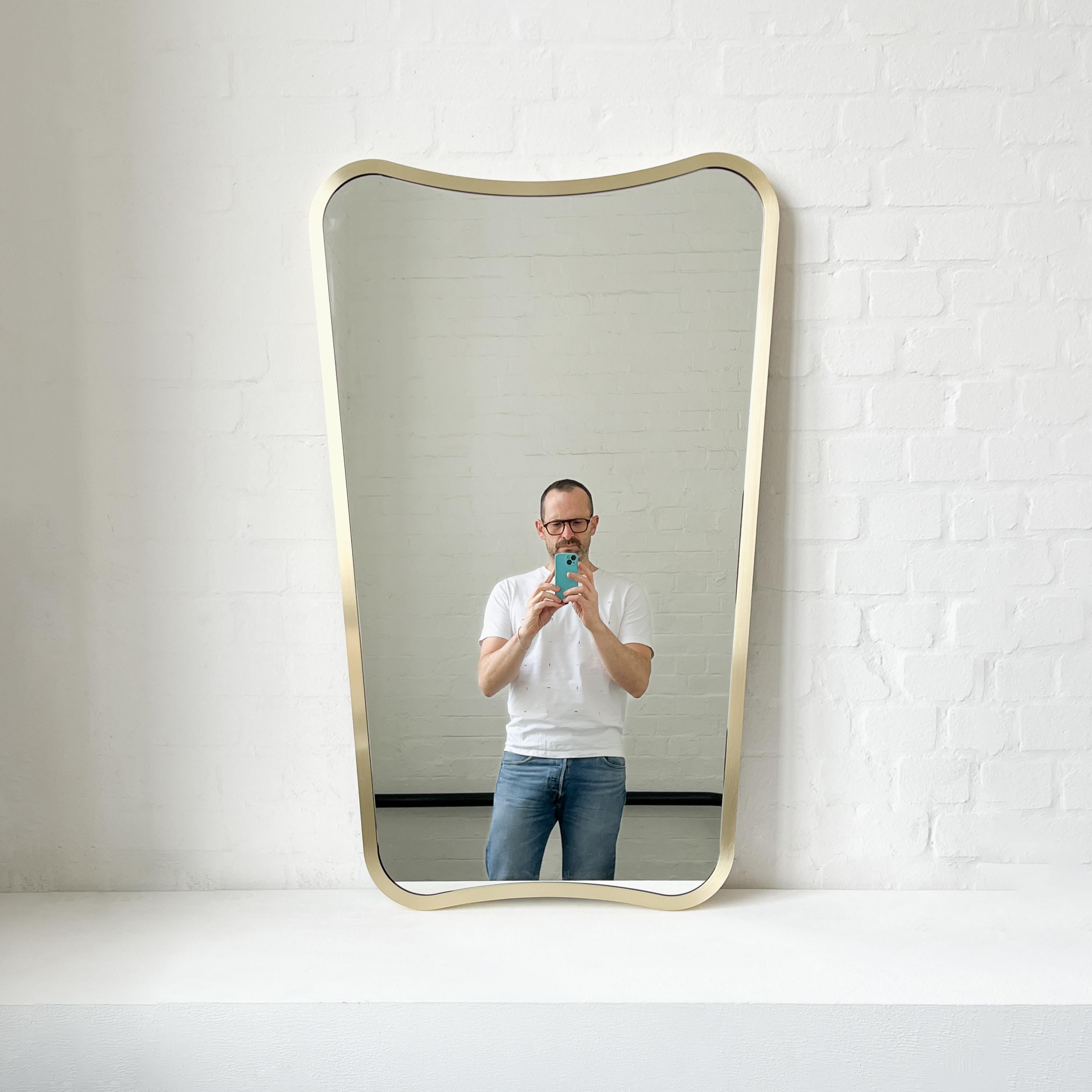 Miroir de style mid century avec un élégant cadre plein en laiton brossé inspiré par le célèbre travail du designer italien Gio Ponti. Fabriqué à la main à Londres, au Royaume-Uni, selon des normes de qualité élevées, en laiton massif