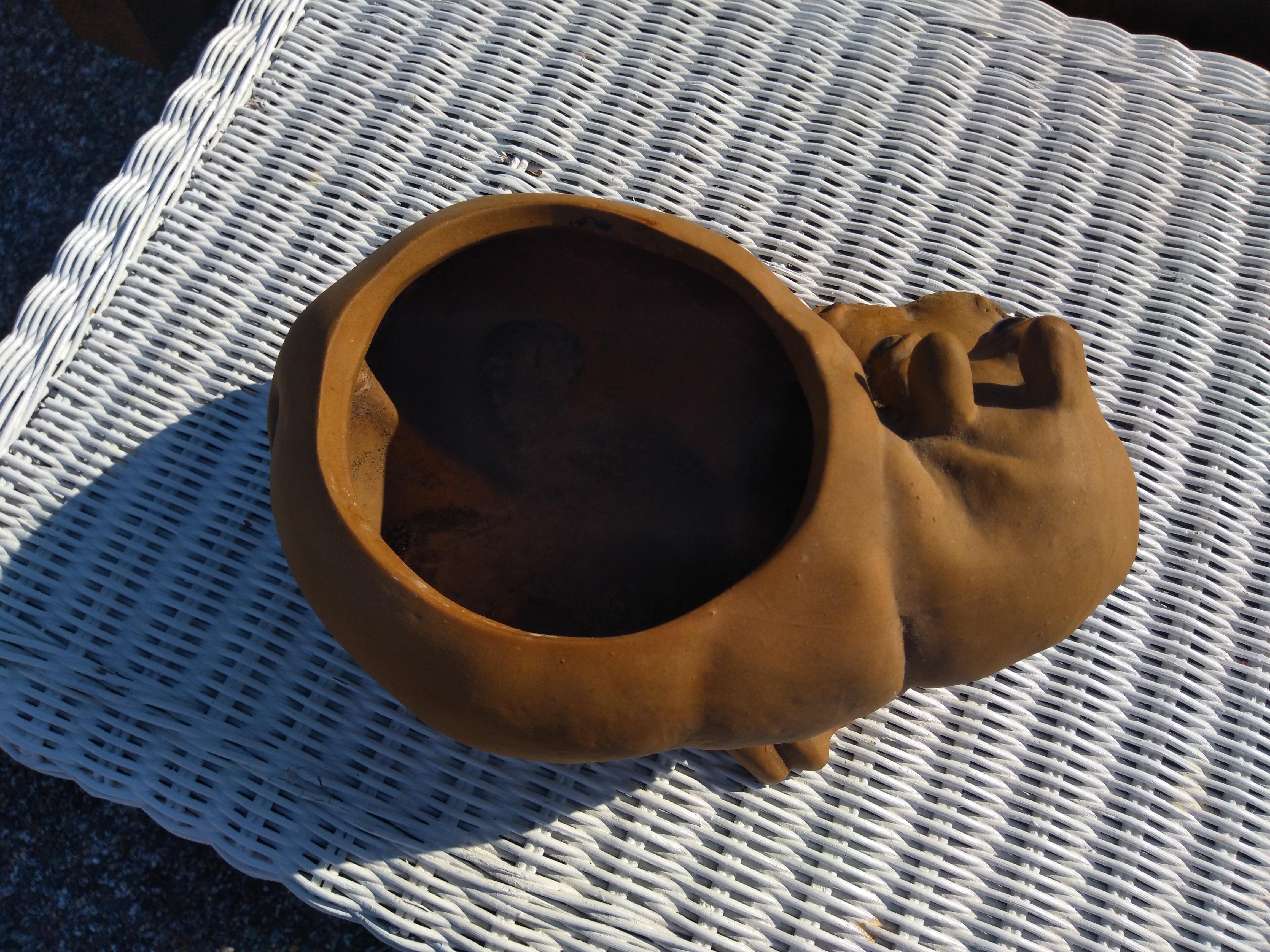 This clay planter was handcrafted by the artist named Anthony. It depicts a Hippo looking over it's shoulder. A nice addition to your home or garden.