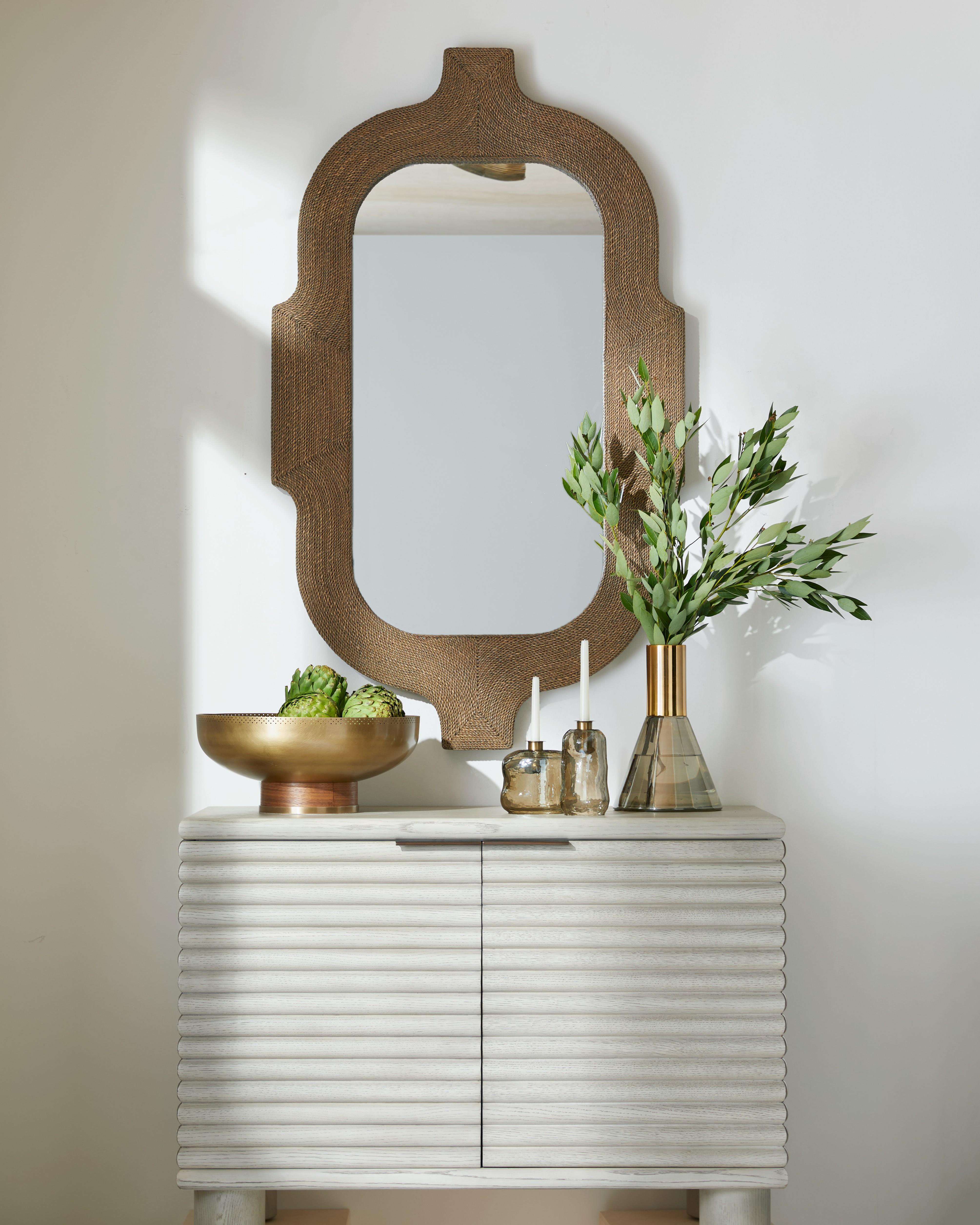Freeport Wall Mirror

The architecturally inspired Freeport gains a distinctive edge with its tobacco-stained abaca rope wrapping, bringing natural warmth and tactile texture to its bold design. With a silhouette influenced by traditional Indian