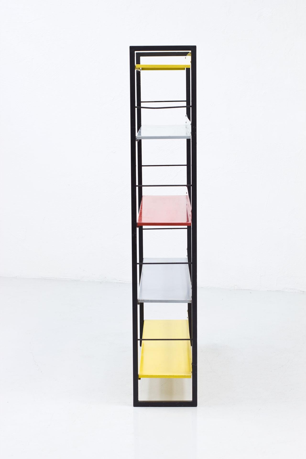 Bookcase, shelving system designed by Adriaan Dekker, 
manufactured by Tomado in the Netherlands during the late 1950s. 
Black metal risers with yellow, red & grey metal shelves.