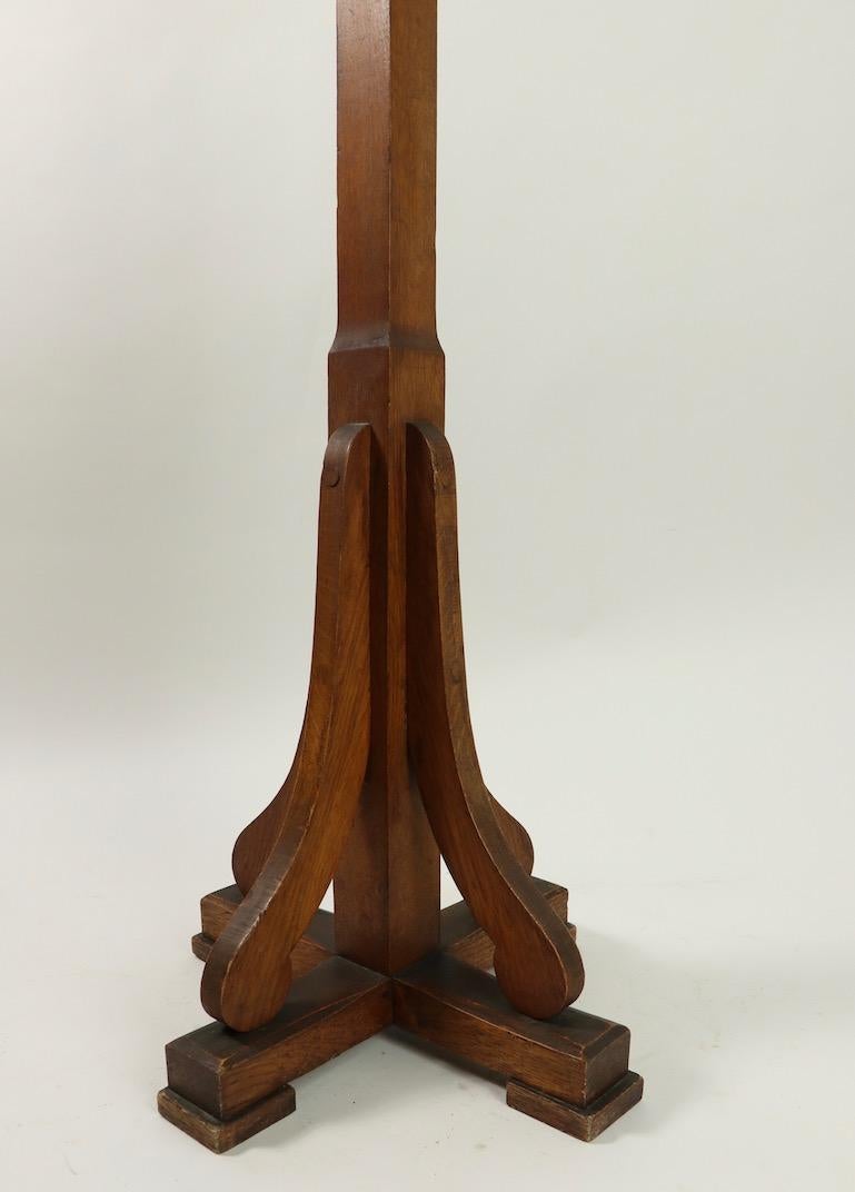 Nice freestanding turn of the century, Arts & Crafts style coat stand having four two prong hooks (coat and hat or scarf), unusual staggered placement of hooks, and decorative base. Sturdy and stable, clean, original and ready to use condition.