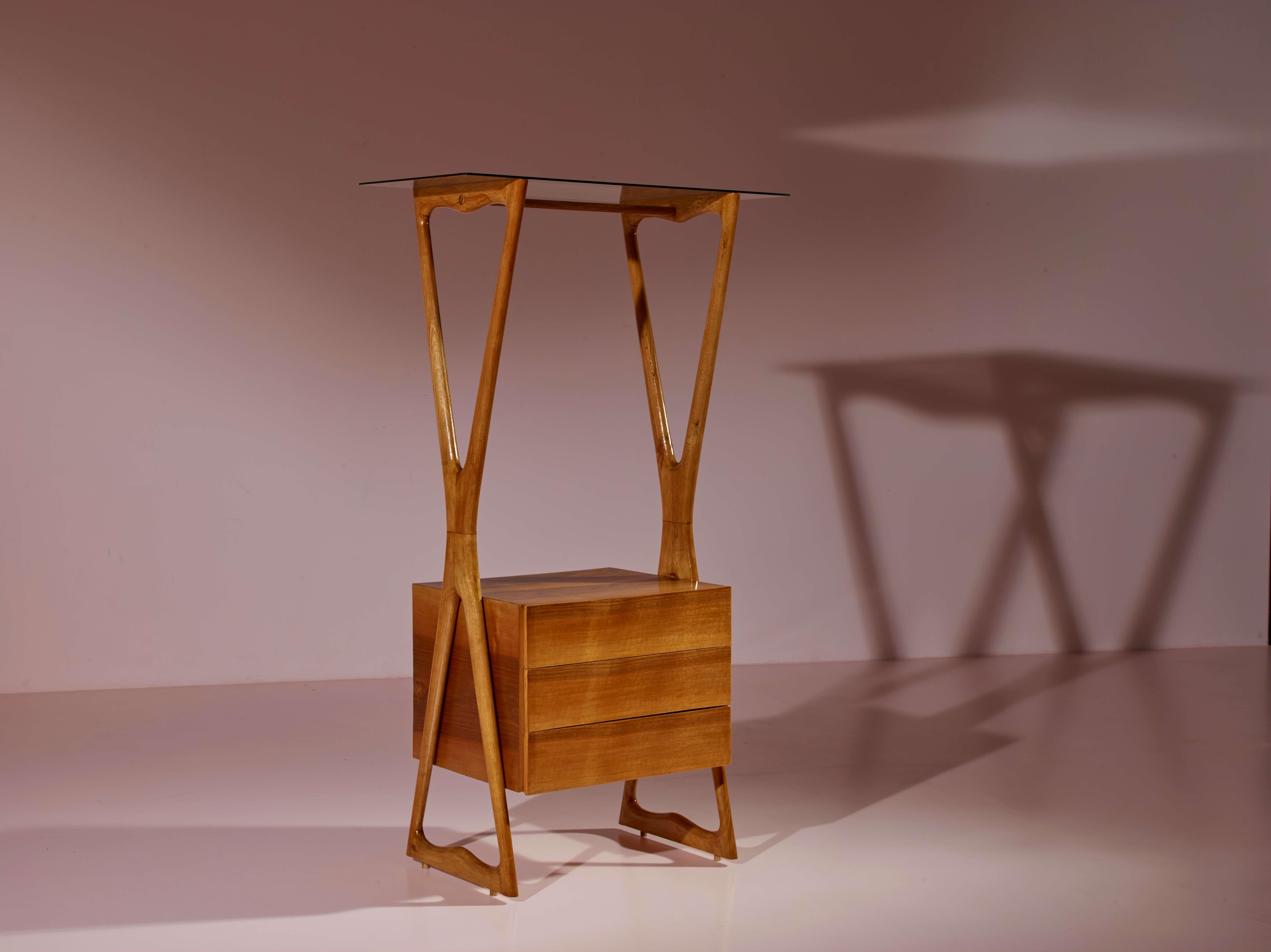 Aparador móvil con cajones, estantes y perchero, fabricado en madera de nogal, cristal y latón, manufactura italiana de los años 50.

Esencial para una entrada y muy útil en un vestidor, este aparcacoches es un mueble poco común diseñado para un