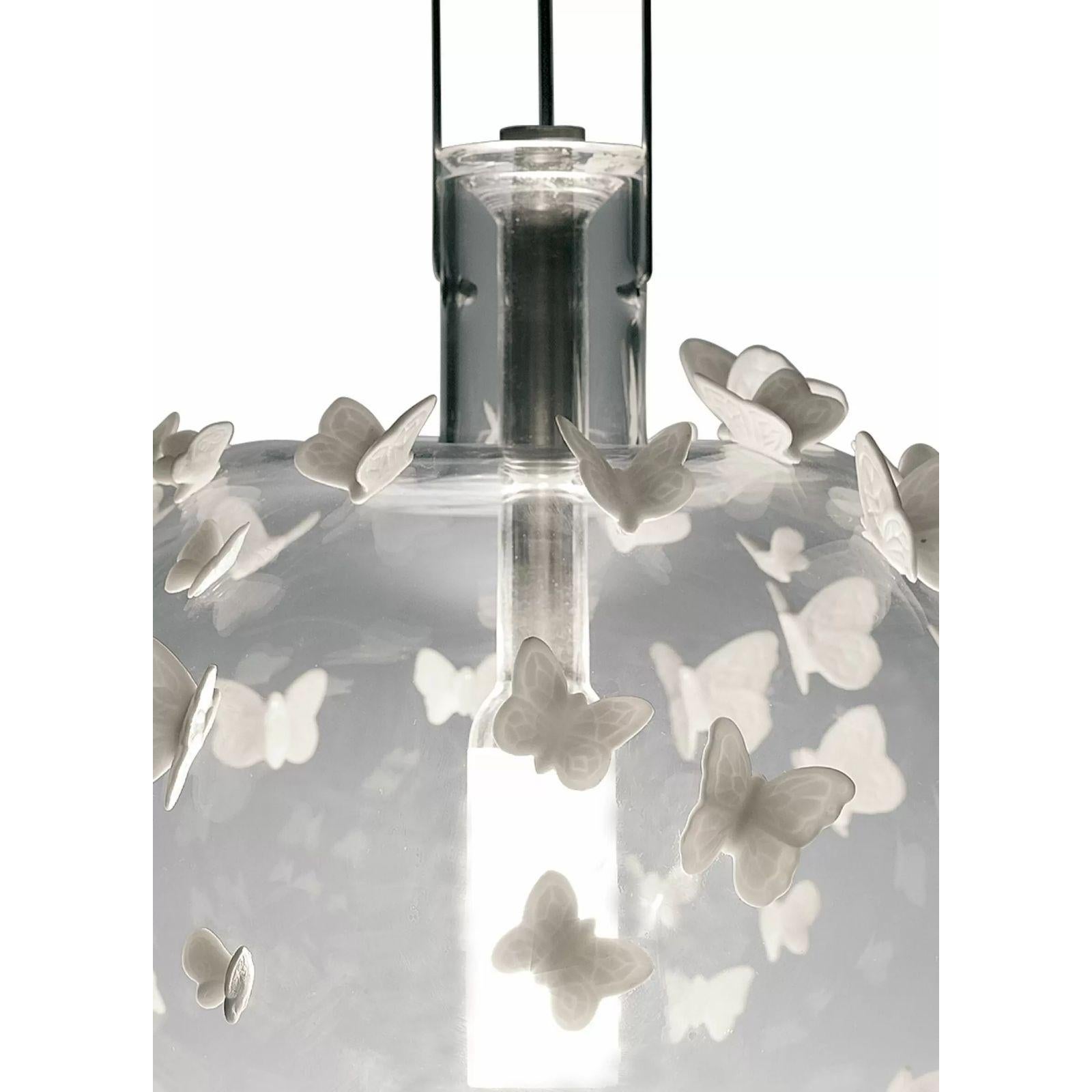 Lampada da soffitto a sospensione in vetro soffiato con applicazioni di farfalle in porcellana fatte a mano.

Lampada a sospensione in vetro con farfalle in porcellana. Questa spettacolare lampada a sospensione scultorea combina vetro soffiato a