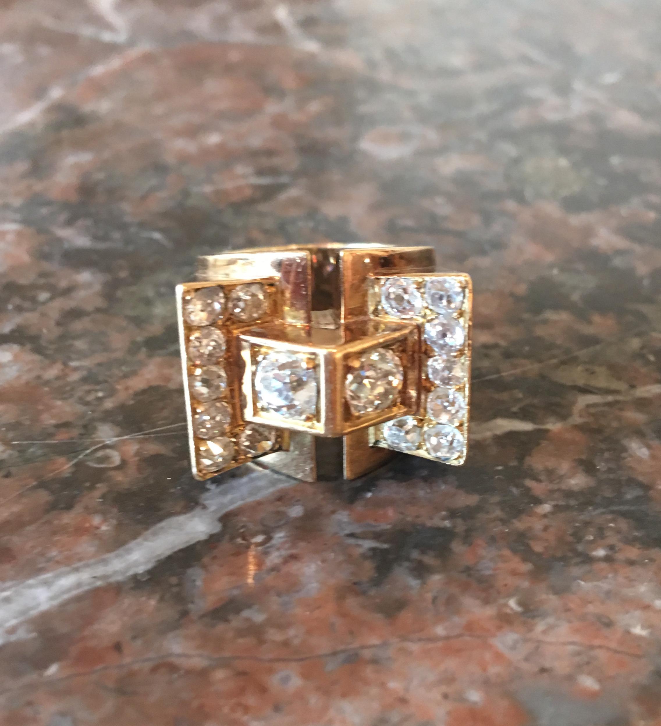 A large French 18K Yellow Gold and diamond ring with geometric design set with 2 larger Old cut diamonds and 7 smaller old cut diamonds on each side

The two central old cut diamonds are weighing approx 0.33 carats (4.5 mm) each  I-J colour and