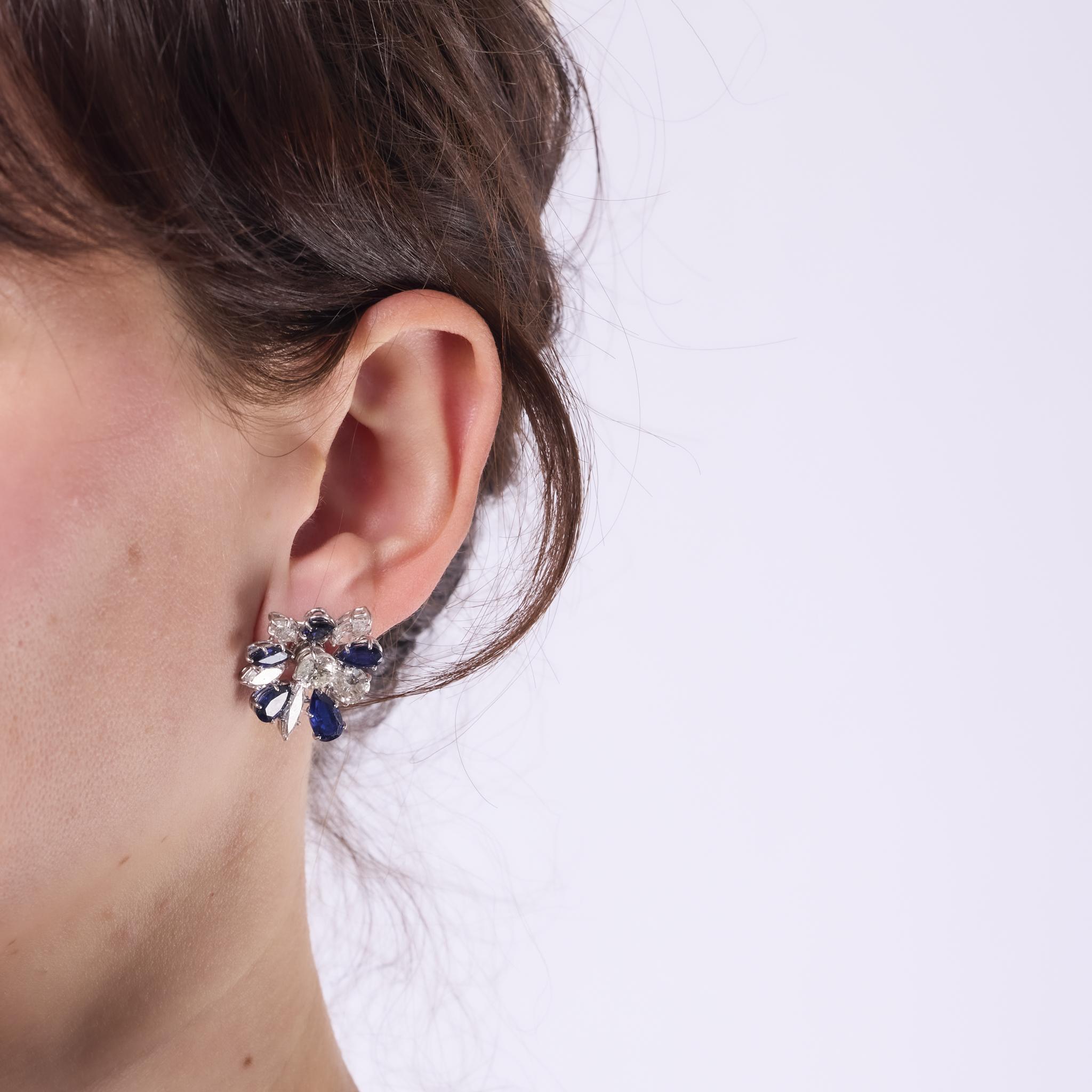 These dazzling French Mid Century earrings showcase a stunning 14.60 total carat weight of brilliant white diamonds and vivid blue sapphires. Crafted in platinum with 18k white gold backs, their radiant 1950s design offers timeless elegance and