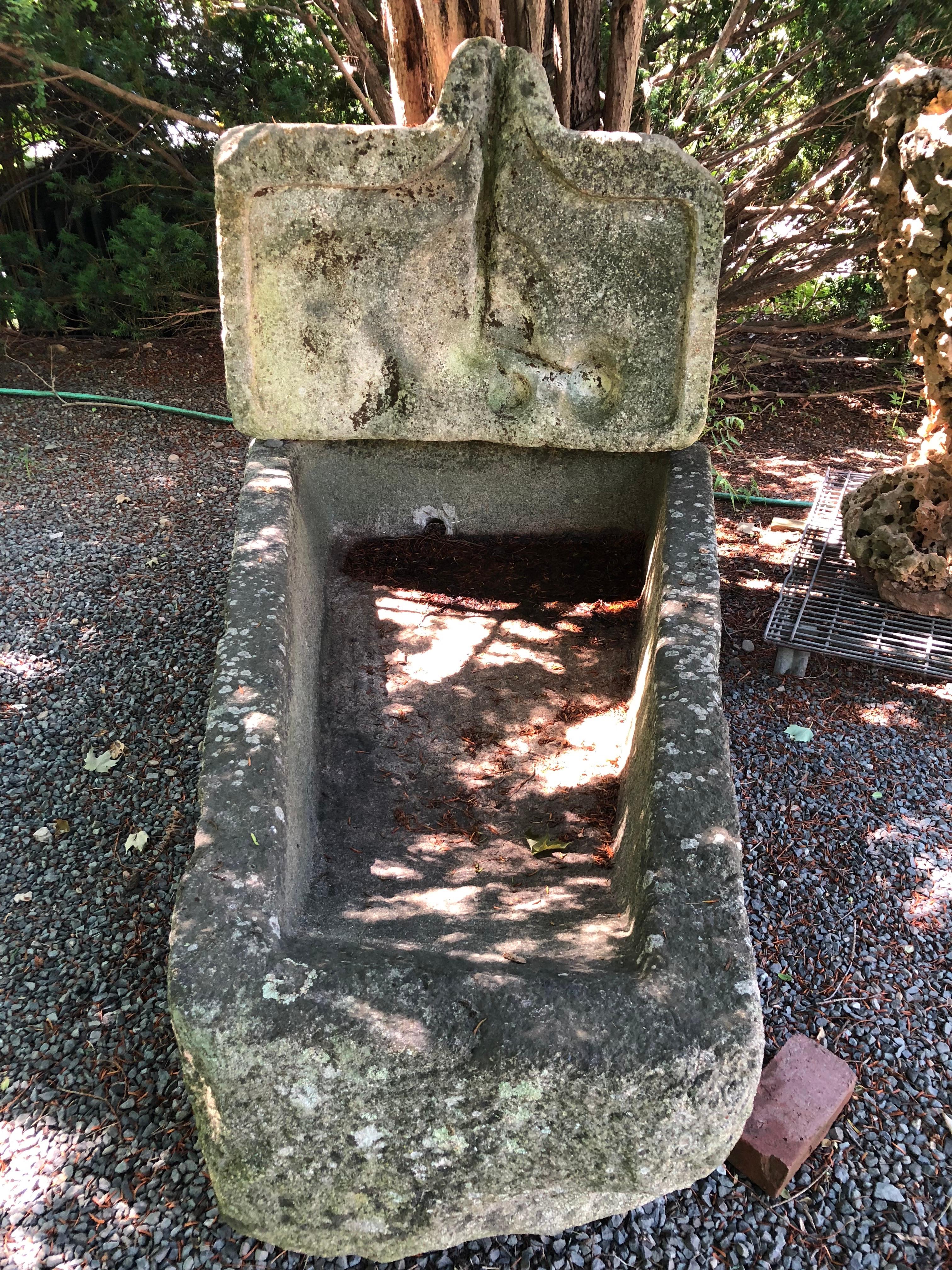 This rare and unusual keystone-shaped granite lavoir trough is from Sathe, France and dates to the 15th century. In amazing weathered condition, it has a contemporary feel because of its shape and color and would make an stunning focal point in your