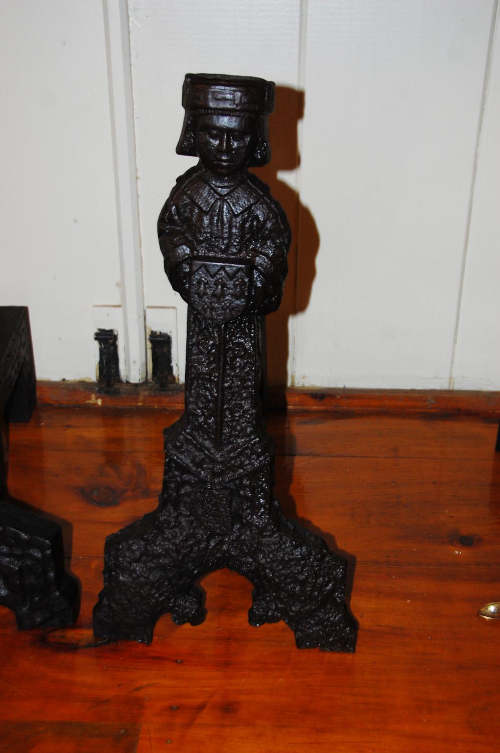 French Francis the First Renaissance Period cast iron andirons in the shape of courtiers with their signature caps and arms holding shields bearing fleur de lys. These truly rare andirons were created when the vagaries of casting iron were far from