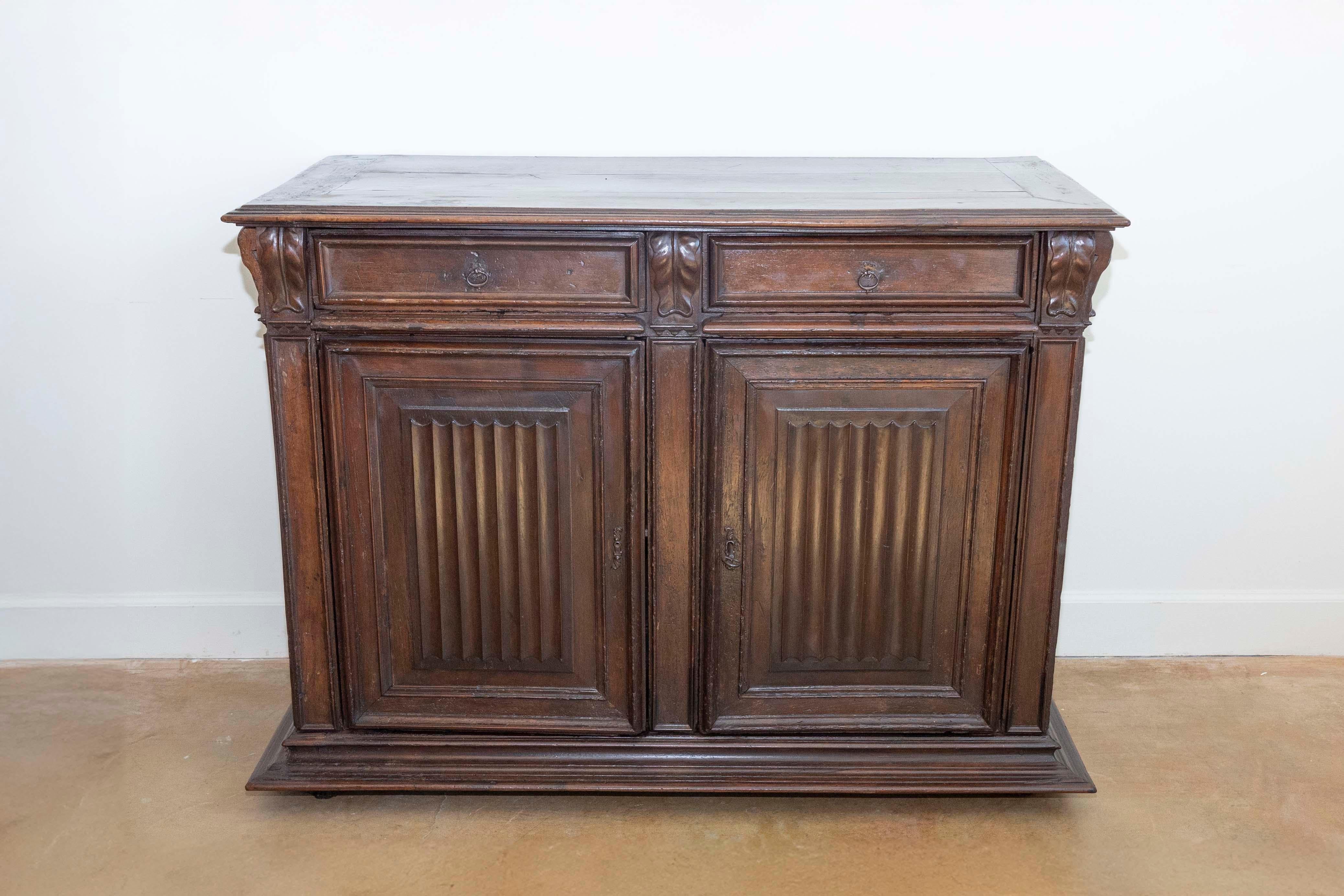 Un buffet francese in noce rinascimentale del periodo Henri II, risalente al XVI secolo, con decorazioni in stoffa piegata intagliata, due cassetti su due ante e motivi di foglie d'acanto intagliate. Questo buffet francese in noce rinascimentale del