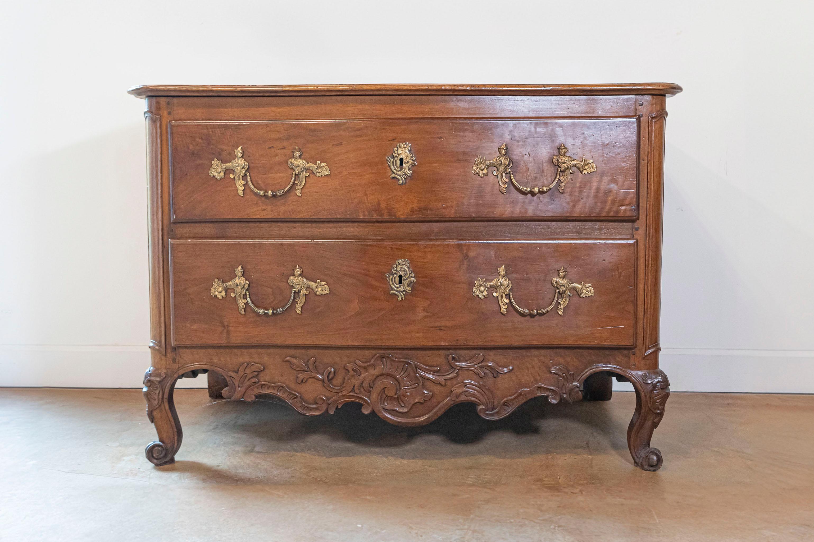 Commode a due cassetti di epoca Luigi XV della metà del XVIII secolo, con grembiule intagliato, gambe a cabriola e ferramenta in stile rococò. Nata in Francia durante il regno del re Luigi XV e soprannominata le Bien-Aimé (l'Amato), questa commode
