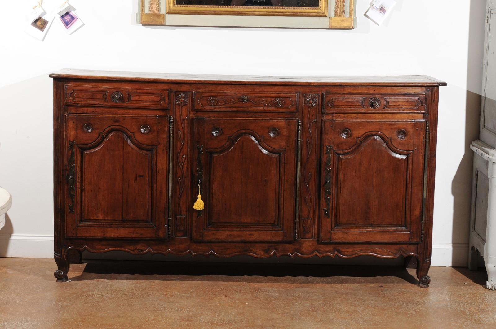 ON HOLD A northern French mid-18th century cherry wood enfilade from Picardy with three drawers over three doors and floral décor. Born during the reign of king Louis XV, this French cherry enfilade features a rectangular planked top with rounded