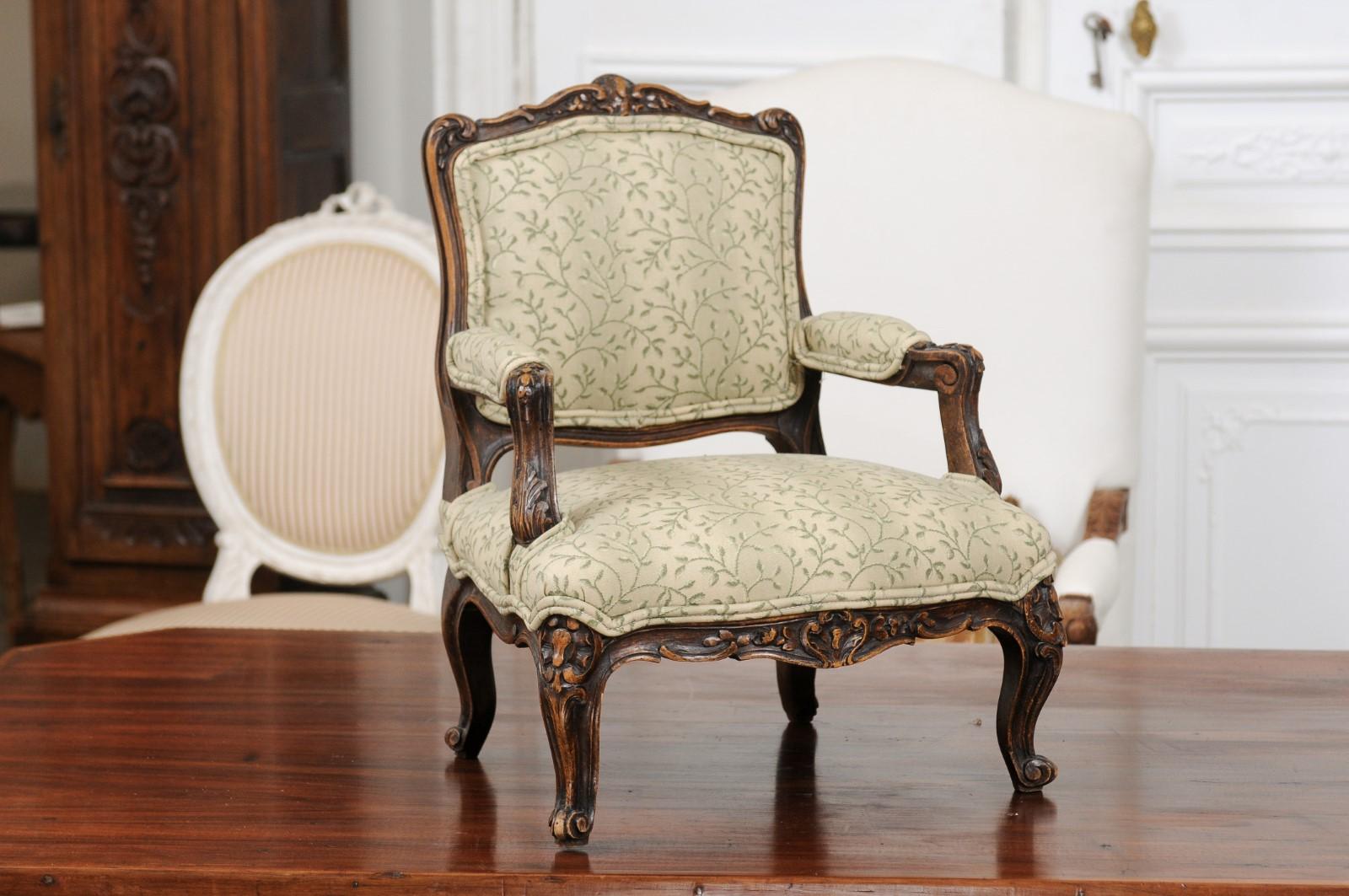 A petite French Louis XV period apprentice chair from the mid-18th century, with new floral upholstery. Born in France during the reign of King Louis XV nicknamed the beloved and created to demonstrate an apprentice menuisier's skill, this petite