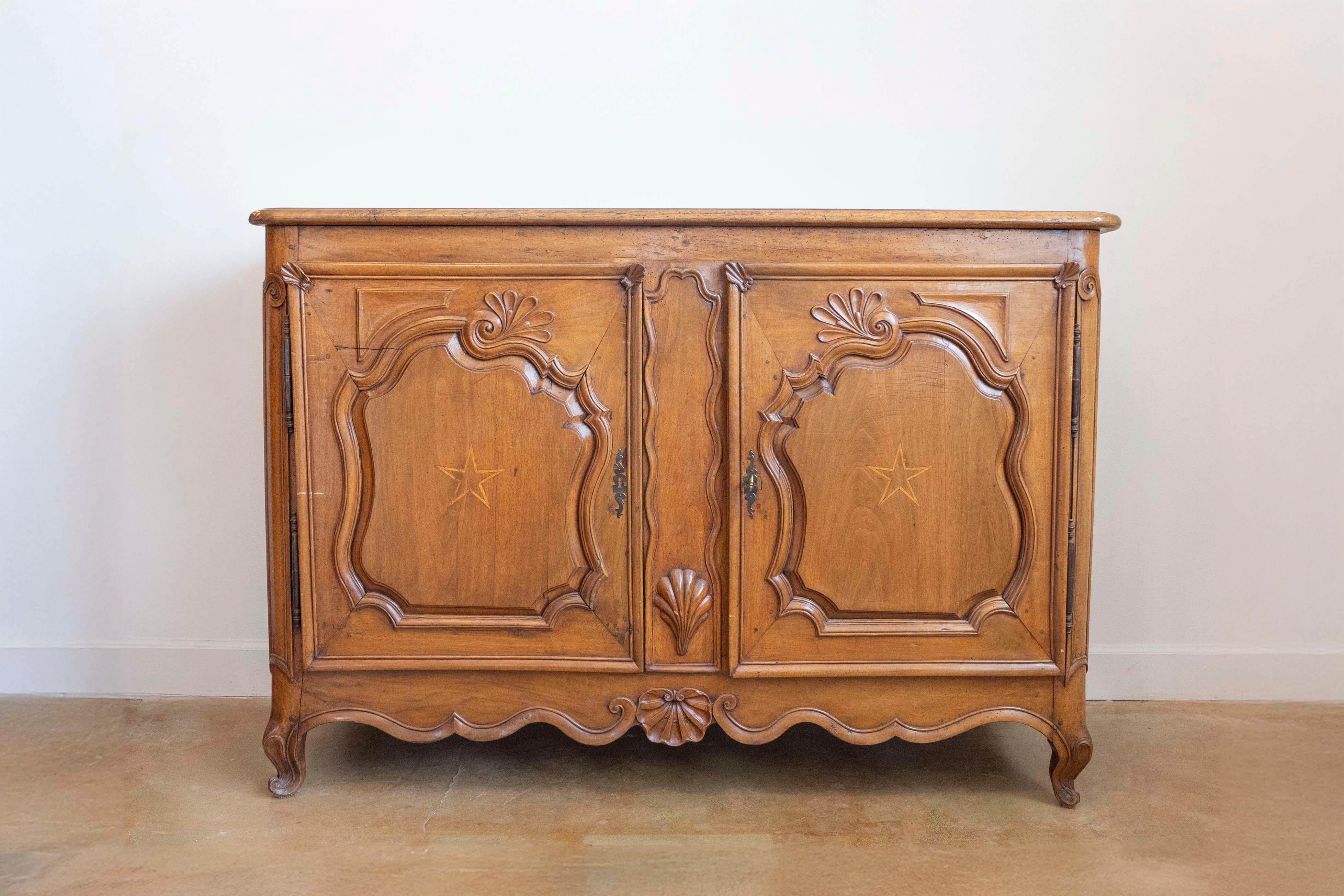 Un buffet francese in noce di epoca Luigi XV della metà del XVIII secolo, con intarsio di stelle e conchiglie intagliate. Creato in Francia durante il regno del re Luigi XV, soprannominato Le Bien-Aimé (l'Amato), questo buffet in noce presenta un
