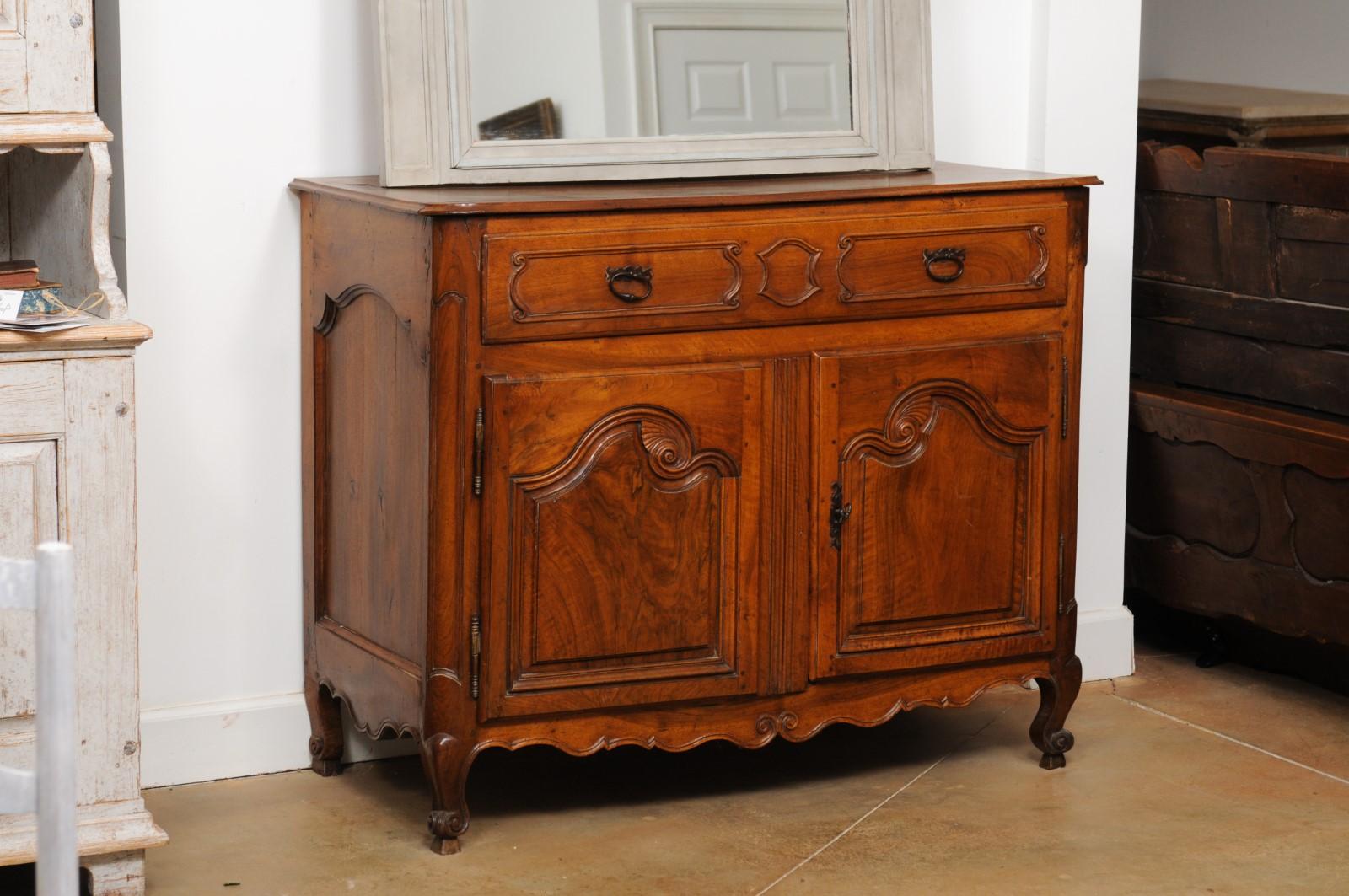 A French Louis XV period mid-18th century walnut buffet from Provence with single drawer and two doors. Created in Provence during the reign of King Louis XV nicknamed the Beloved (le Bien-Aimé), this southern French walnut buffet features a