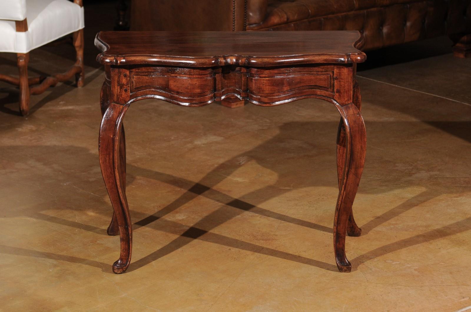 A French Louis XV period walnut console table from the mid 18th century, with cabriole legs. Born during the reign of king Louis XV, the 