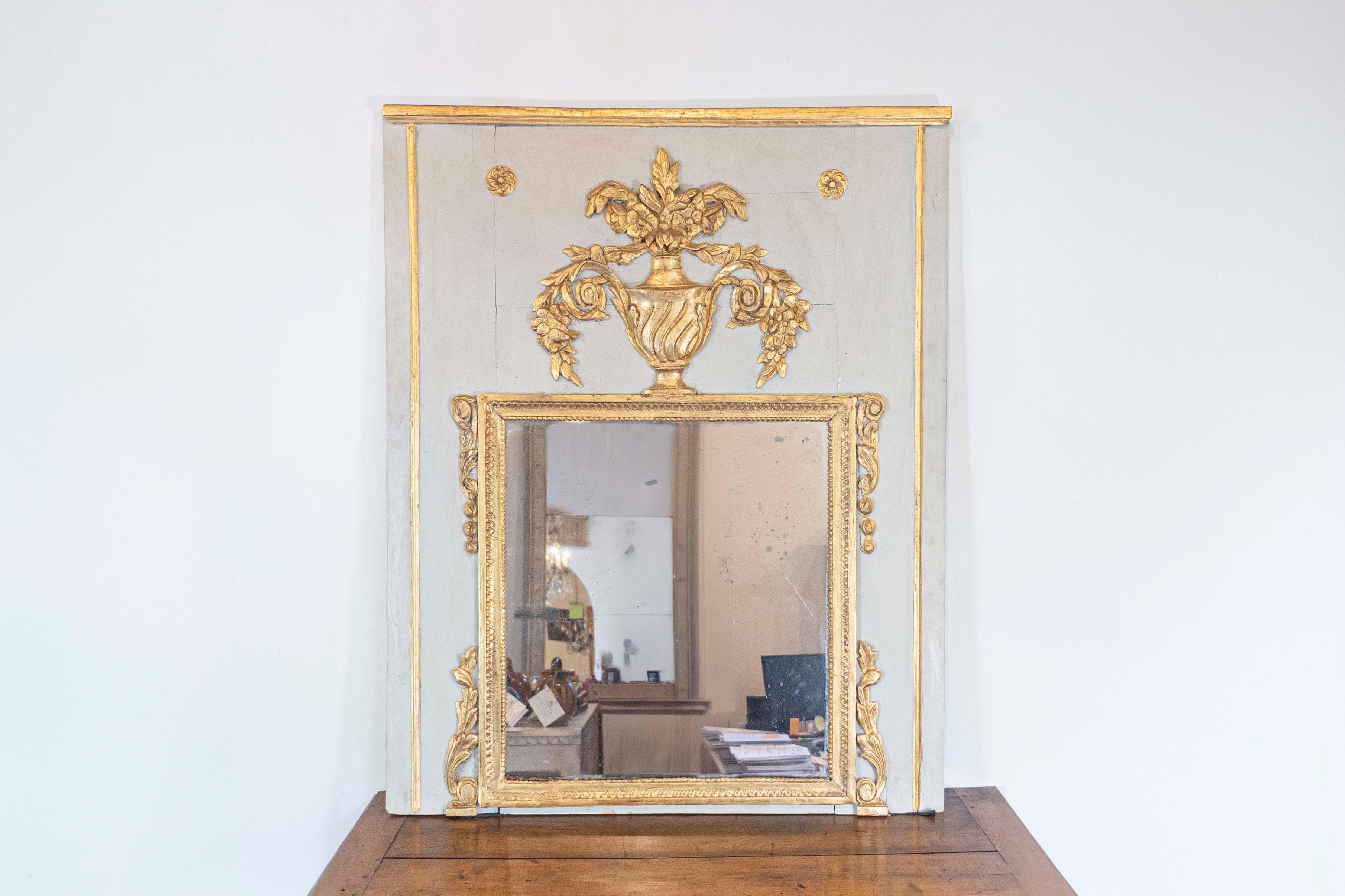 Specchio trumeau francese del XVIII secolo, dipinto e dorato, con urna, fiori, fogliame e volute. Creato in Francia durante il terzo quarto del XVIII secolo, questo specchio trumeau presenta le caratteristiche stilistiche della 