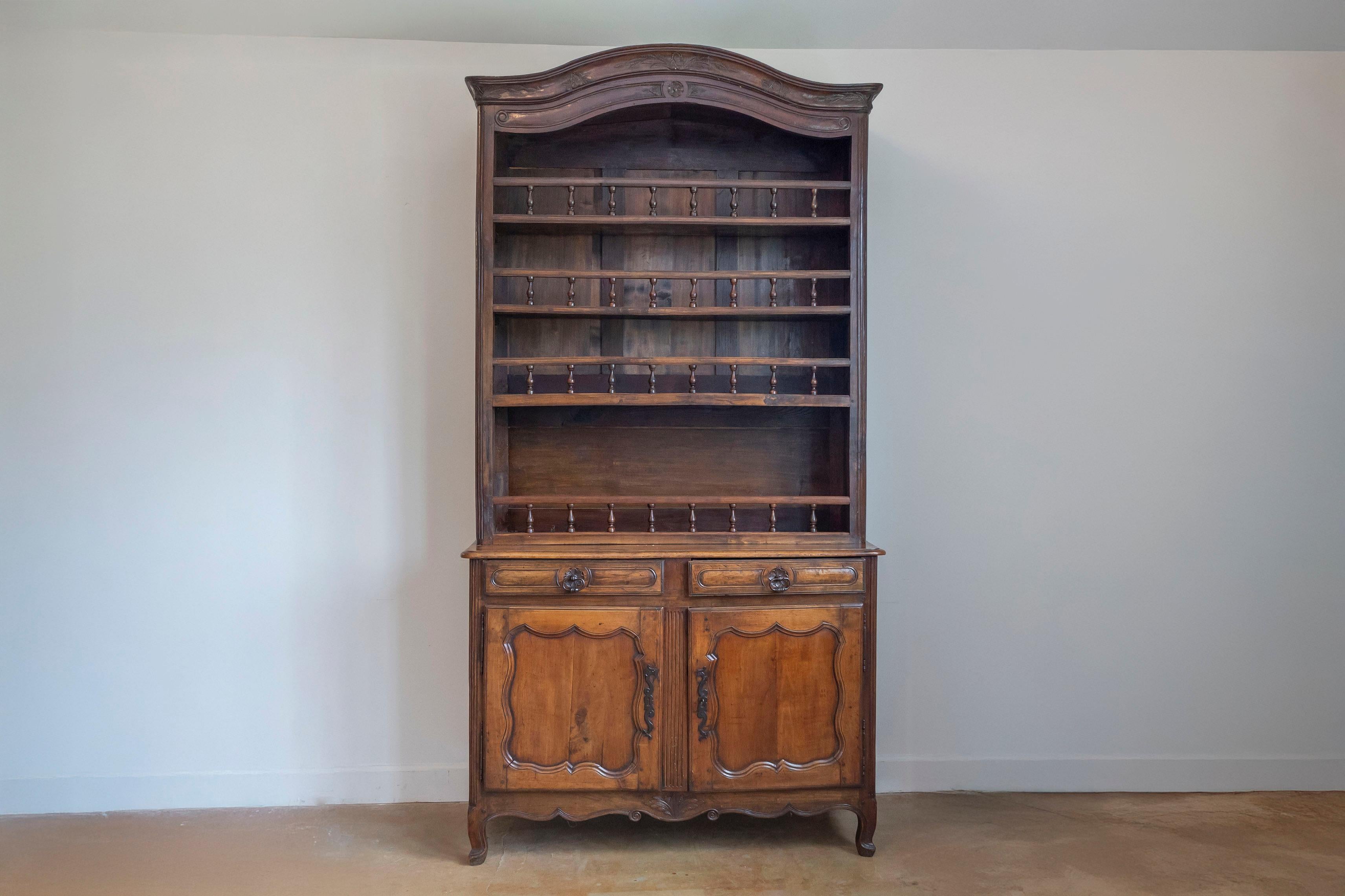 Vaisselier francese della fine del XVIII secolo in stile Luigi XV in ciliegio, con ferramenta originale e ripiani aperti su due cassetti e due ante. Questo buffet francese à deux-corps presenta un frontone a forma di cofano intagliato con delicati