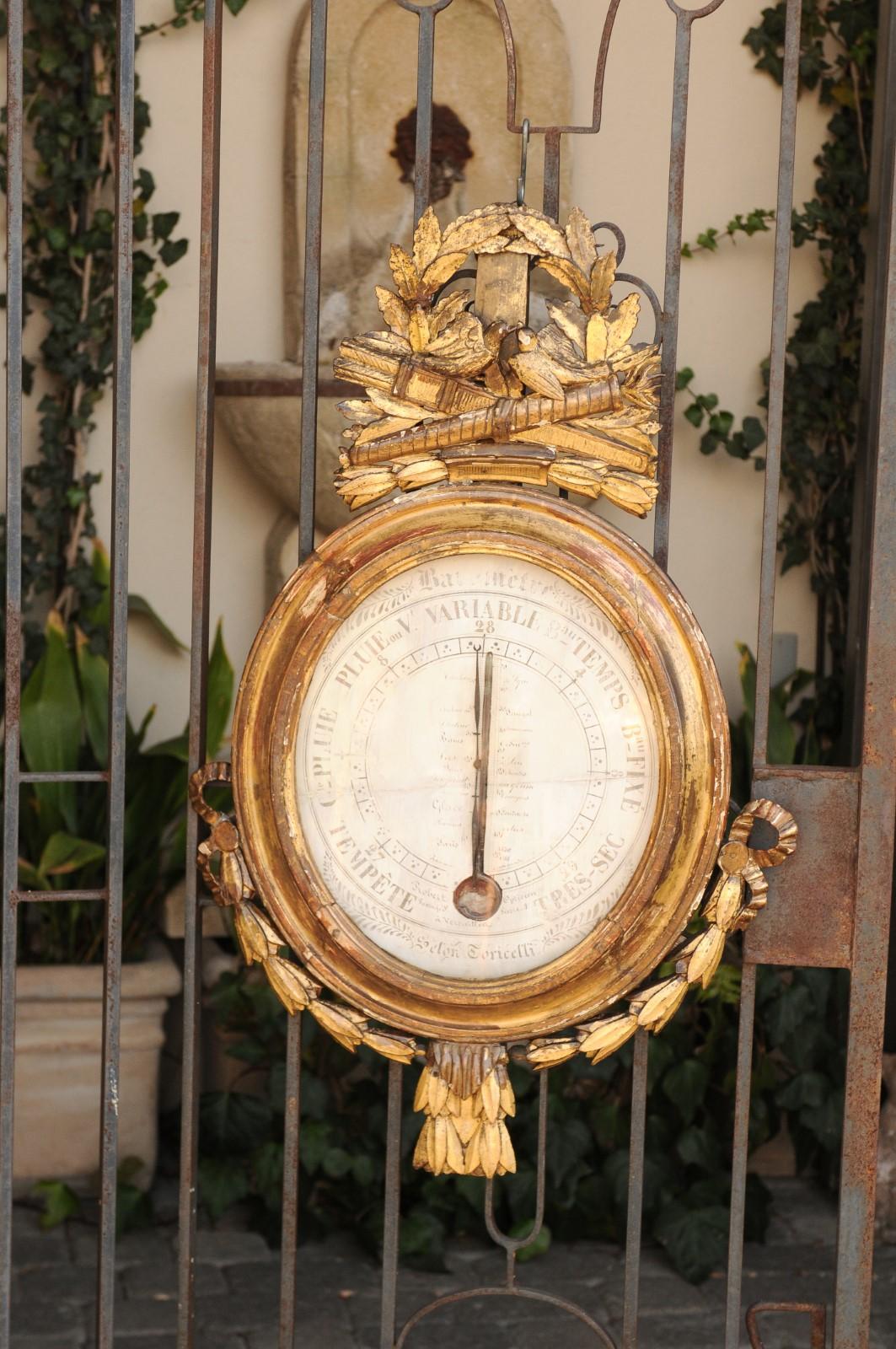 A French Louis XVI period giltwood barometer from the late 18th century, with hand carved hunting trophy and ribbon-tied garland. Born in France during the troubled period of Louis XVI last reigning years, this exquisite barometer 'Selon Toricelli'