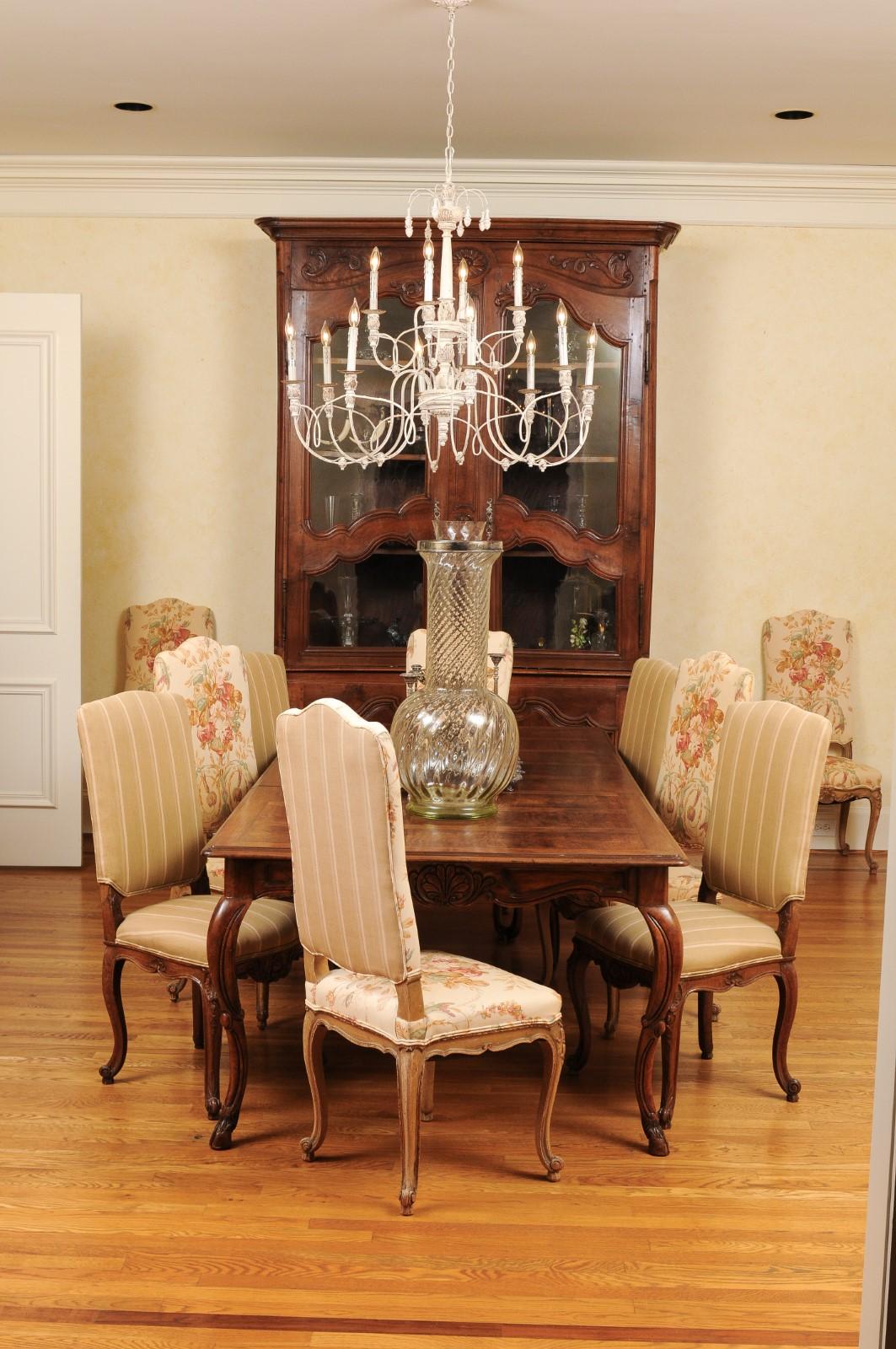 A French walnut buffet à deux-corps from the late 18th century, with glass doors and carved motifs. Created in France at the end of Louis XVI reign, this walnut buffet à deux-corps features a molded cornice sitting above two doors adorned with