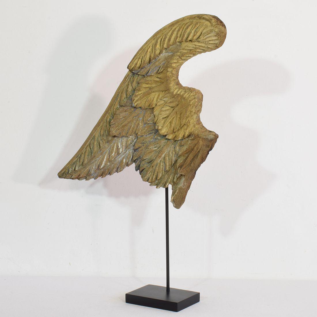 Beautiful pure and simple carved wooden angel-wing. with some traces of paint and gilding. Rare and very decorative item placed on a wooden base, France circa 1650-1750. Weathered. Measurement is inclusive the wooden base.