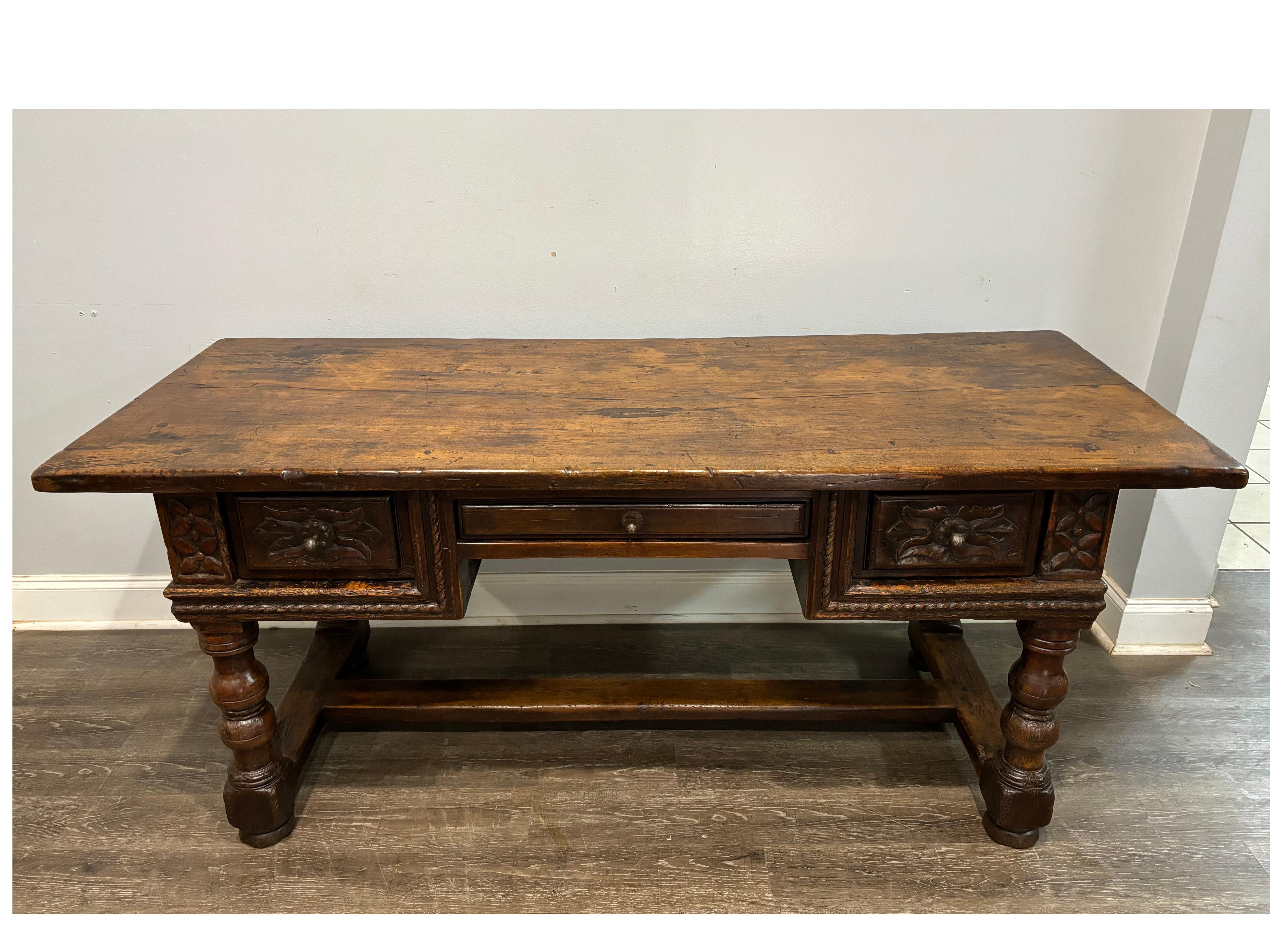 Exceptional desk made of walnut with a wonderful carvings used by the age. The height from the floor to the base of the center drawer is 25''H.
