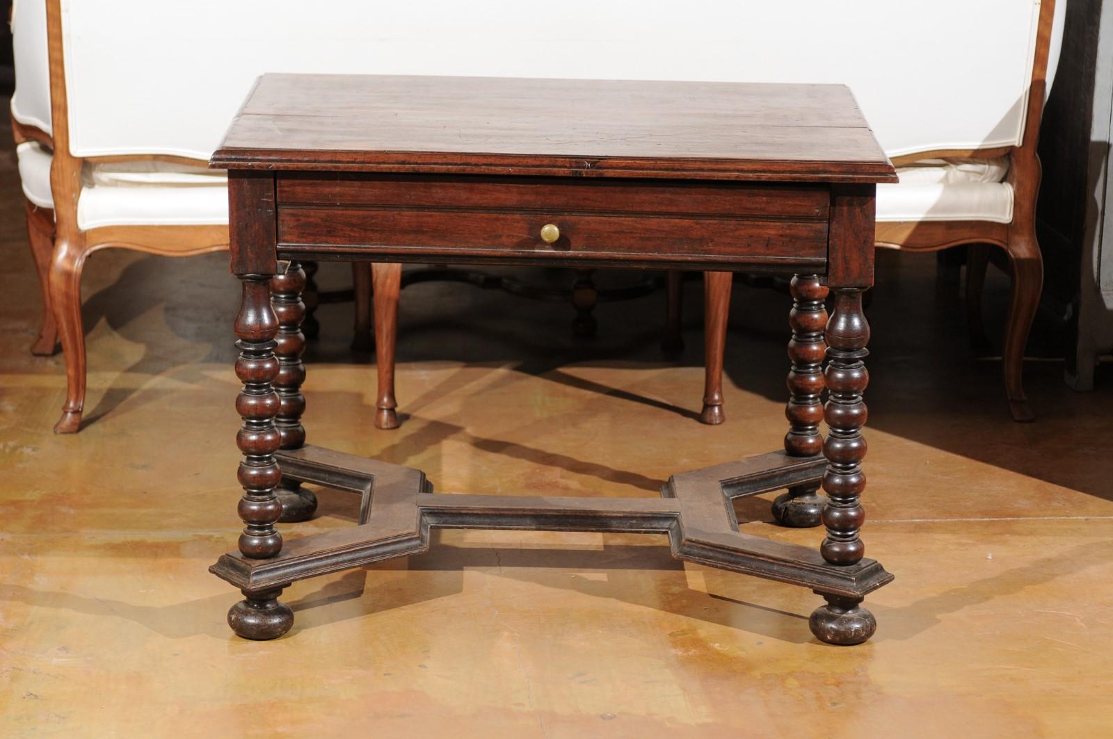 A French 17th century Louis XIII walnut side table with long drawer, bobbin turned legs, cross stretcher and original patina. Born during the second half of the 17th century, at the height of the reign of King Louis XIV, this table bears the