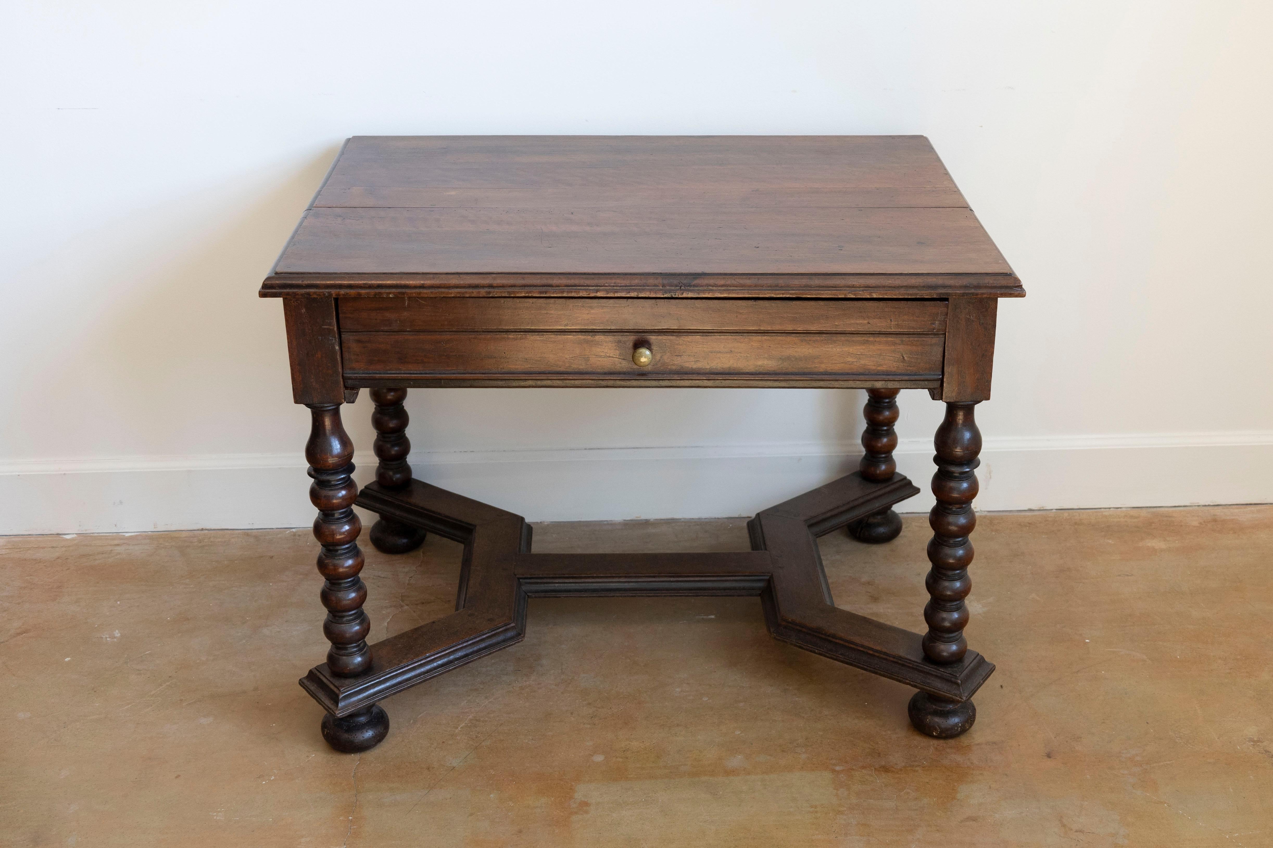 A French 17th century Louis XIII walnut side table with long drawer, bobbin turned legs, cross stretcher and original patina. Born during the second half of the 17th century, at the height of the reign of King Louis XIV, this table bears the