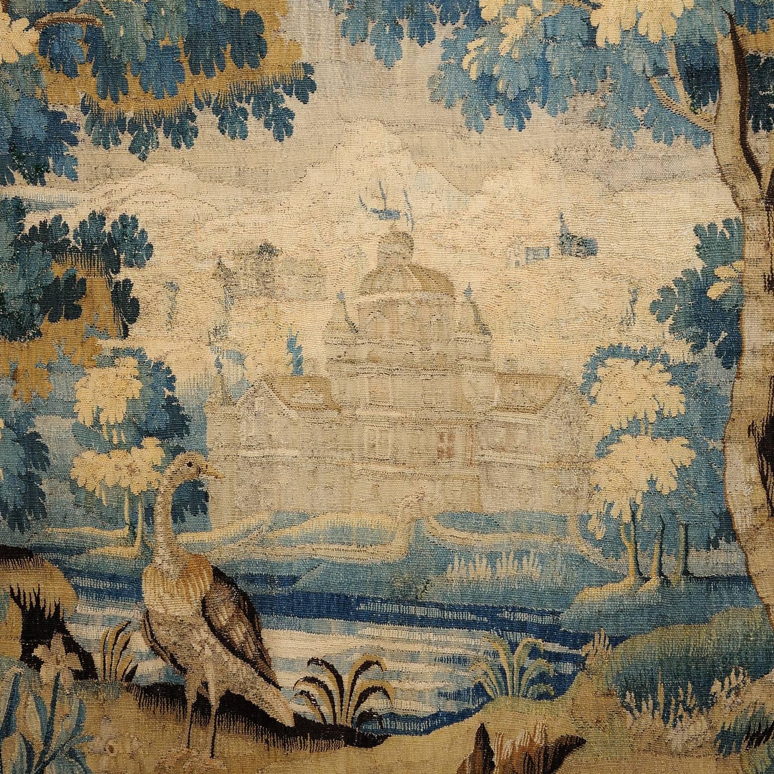 
A large and quite stunning French Louis XIV period verdure tapestry, depicting a beautiful country scene, featuring woodland and birds, an imposing chateau is framed at the centre, circa 1680.
The tapestry was purchased by us from a large