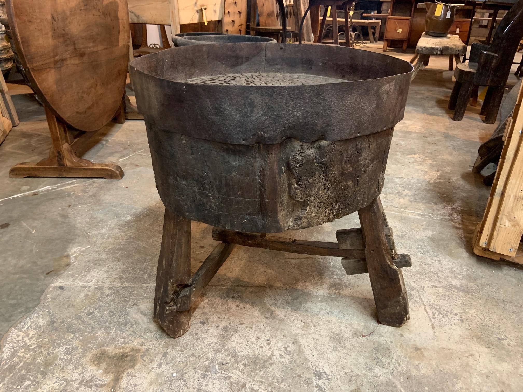 A sensational Arte Populaire Billot used for grinding grains, corn, wheat, etc. It is constructed from a massive billot, chopping block with an iron band around the top so that ground grains would not fall off. There are many iron pieces embedded