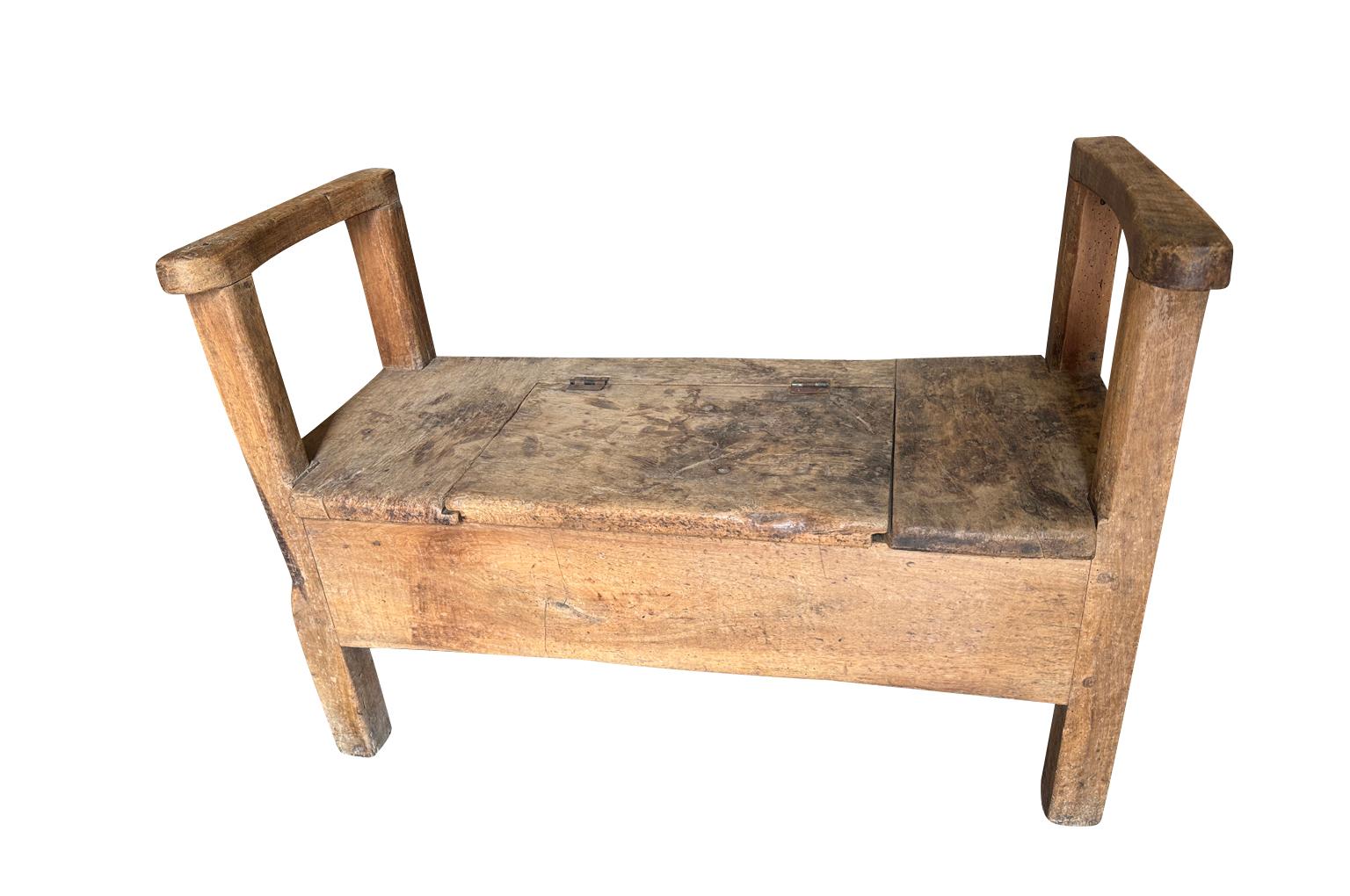 Encantador banco primitivo del siglo XVII procedente de la región francesa de Auvernia. Sólidamente construida en nogal, con brazos y un asiento que se abre para dejar al descubierto la zona de almacenamiento. Gran pátina. 