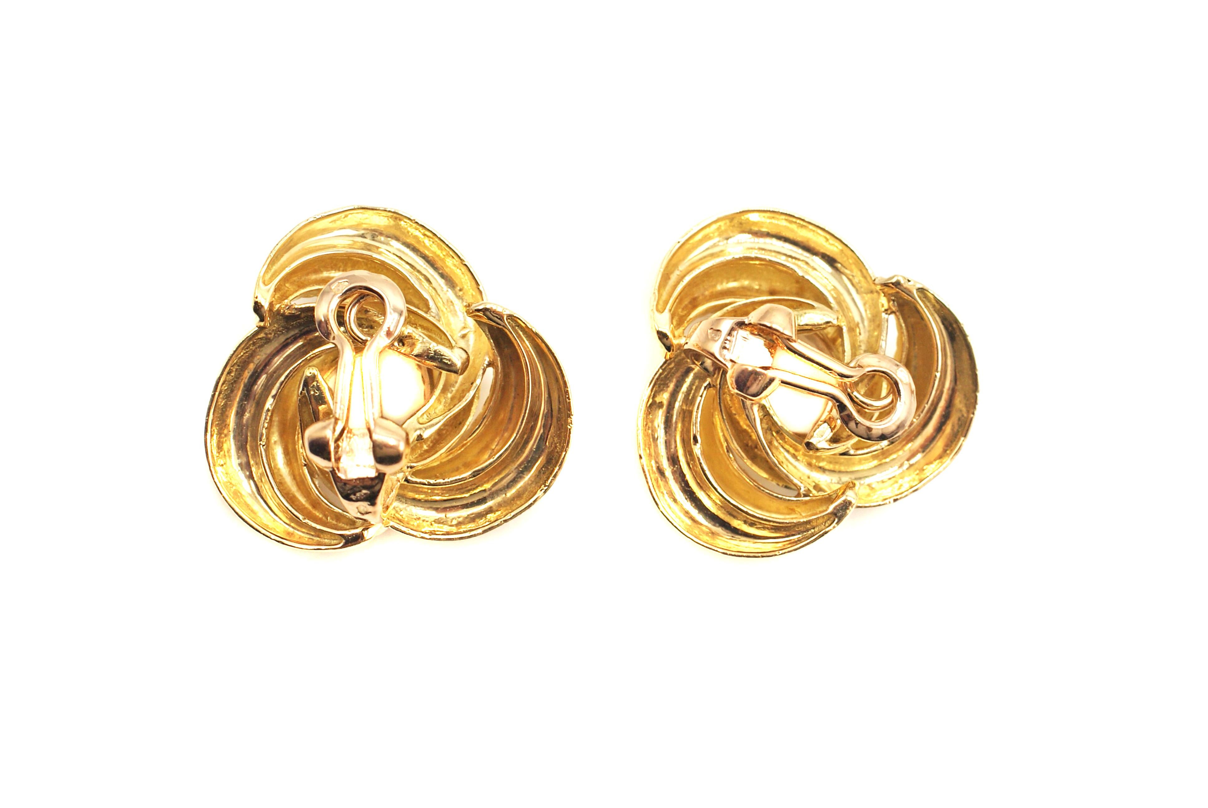 Chic 18 karat yellow gold 1960s ear-clips masterfully hand-crafted as interlocking polished braids of gold. The earring is secured by a comfortable omega back and the weight is perfect for a continuous comfortable wear. French hallmarks on back of