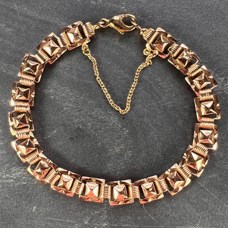 A French 18 karat (18K) rose gold link bracelet designed as a series of connected tank style pyramids. Stamped with the eagle’s head  for 18 karat gold and French manufacture. Lobster clasp closure and safety chain. 7.5 inches long. 

Dimensions: 19
