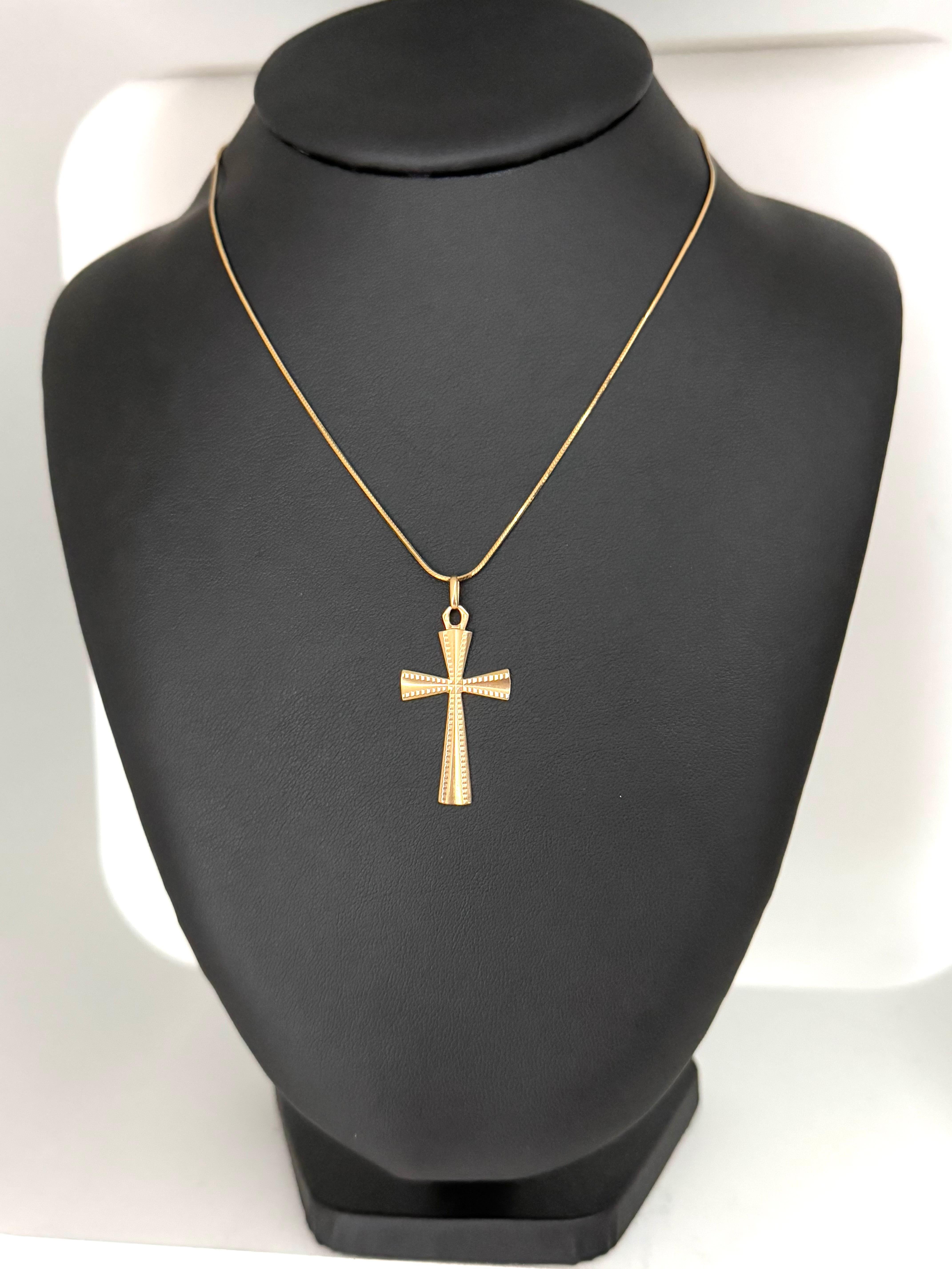
This exquisite antique French cross, crafted in rich 18-karat yellow gold, exudes understated elegance through its masterful textural contrasts. 
The cross features a softly satin-finished surface, lending a muted glow that plays subtly with light.