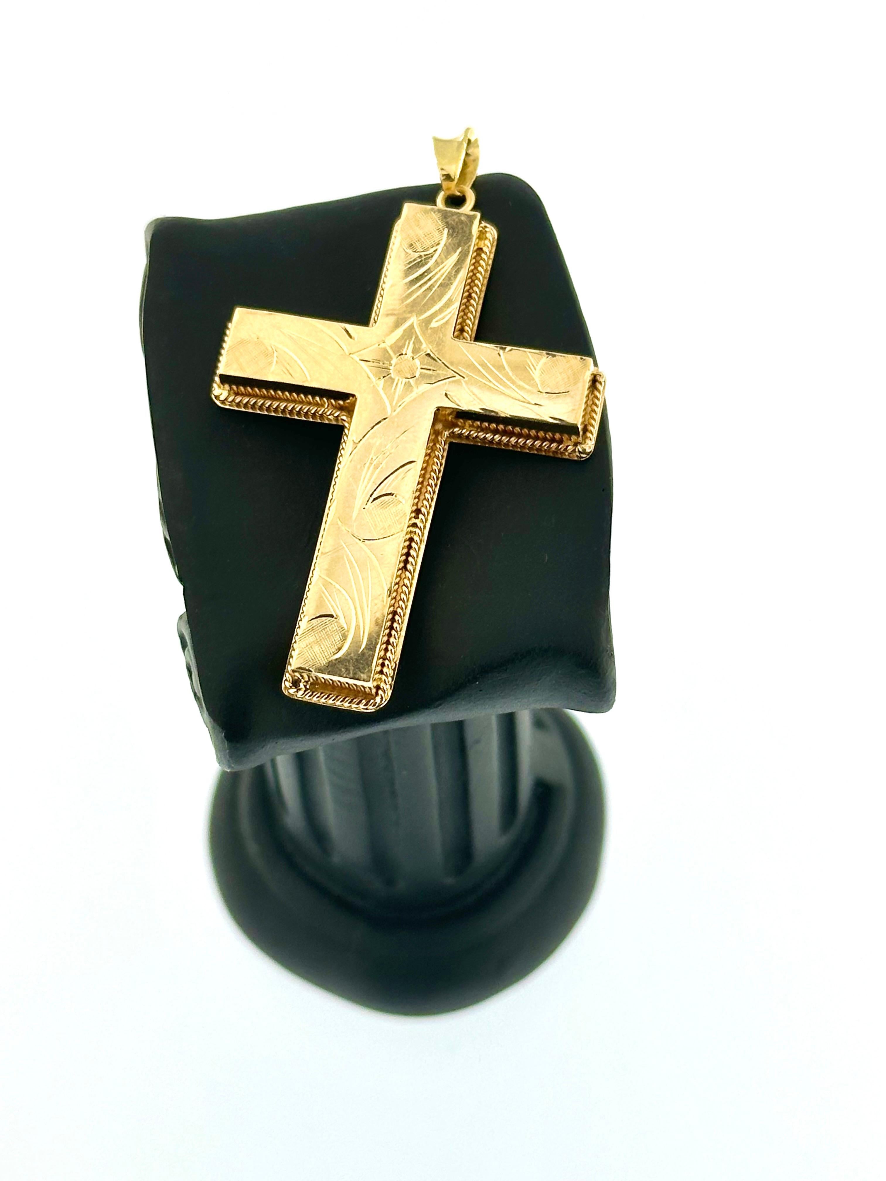 Ce pendentif croix en or jaune 18kt français est un mélange captivant d'élégance et d'artisanat, présentant des motifs floraux et de feuilles complexes qui ajoutent une touche de beauté naturelle. La croix est ornée de délicats motifs de fleurs et