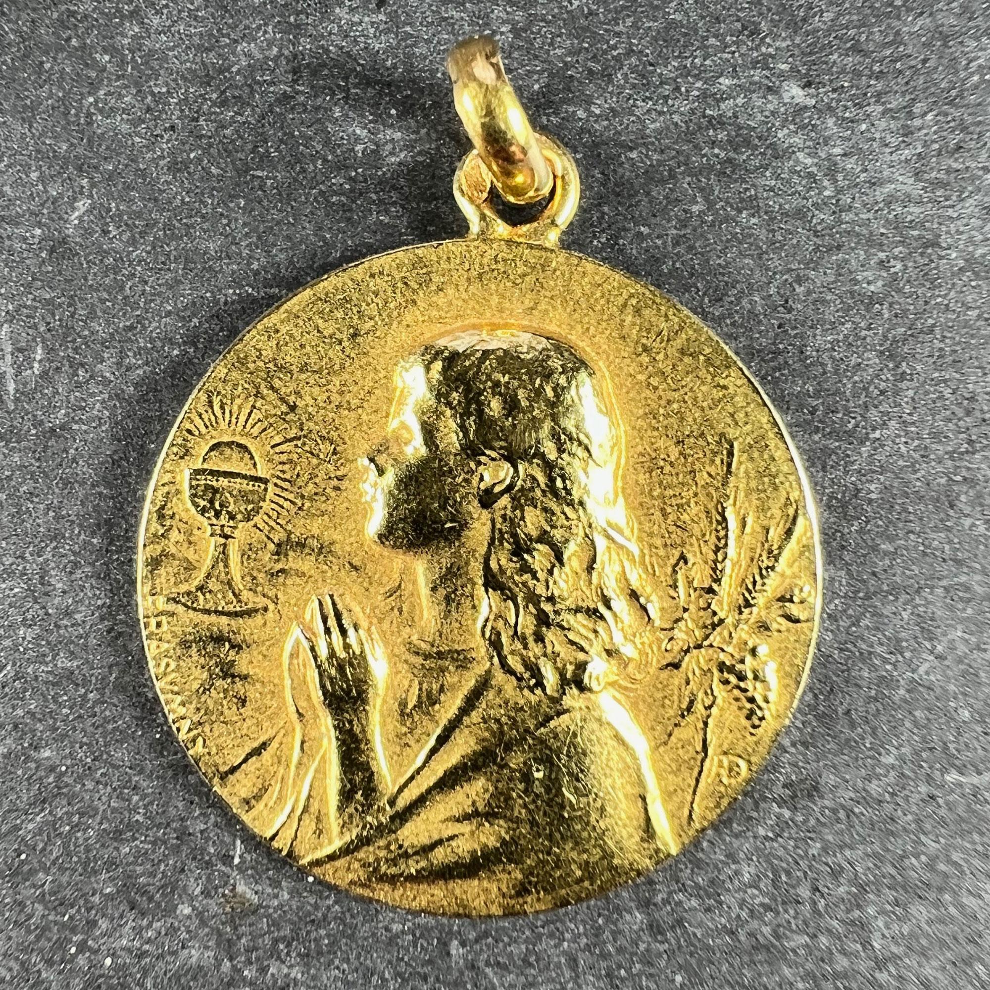 A French 18 karat (18K) yellow gold charm pendant designed as an engraved medal depicting a praying child with a chalice of wine and a bunch of wheat ears, the reverse showing bunches of grapes and wheat.

Signed F. Rasumny for Felix Rasumny